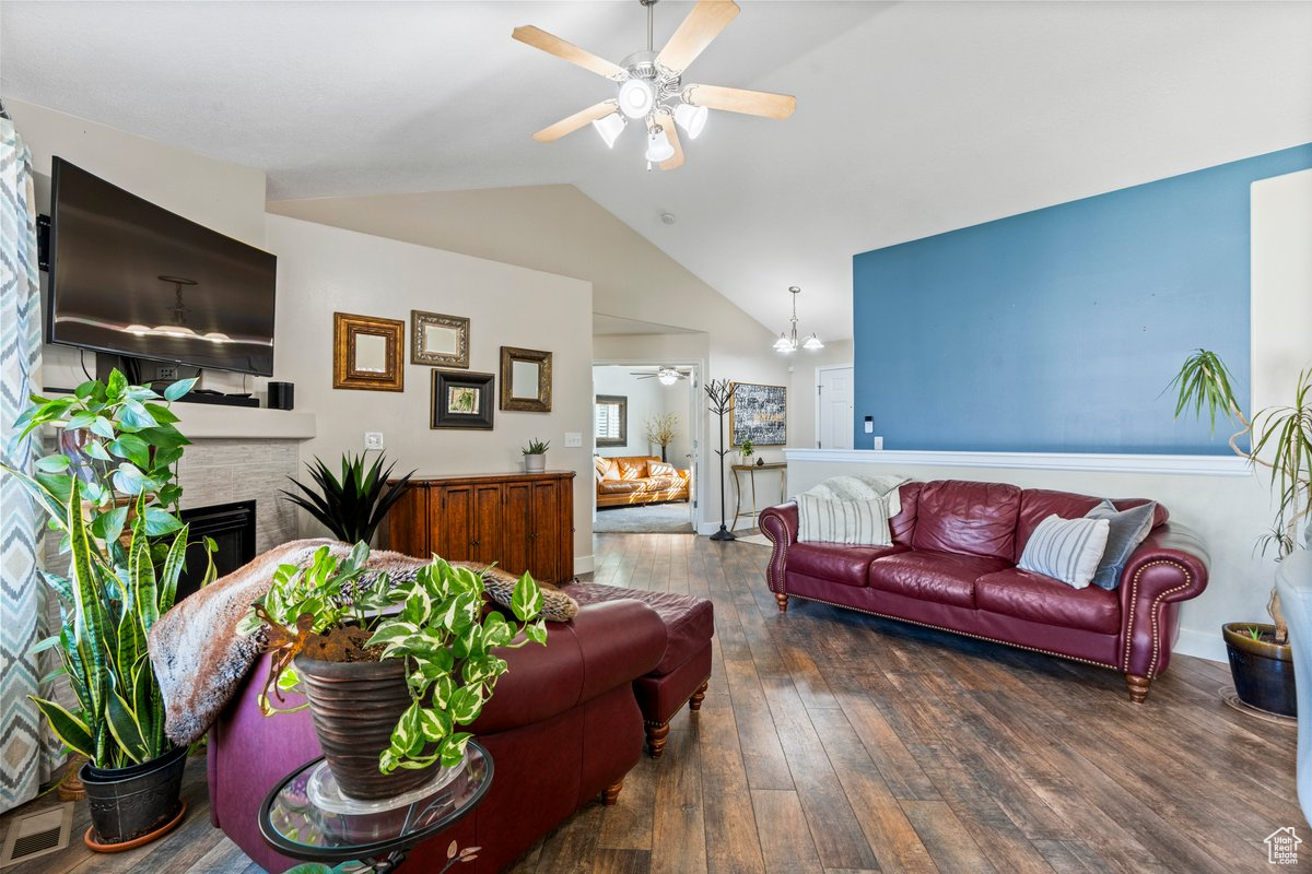 Living room with lofted ceiling, ceiling fan, and hardwood / wood-style floors