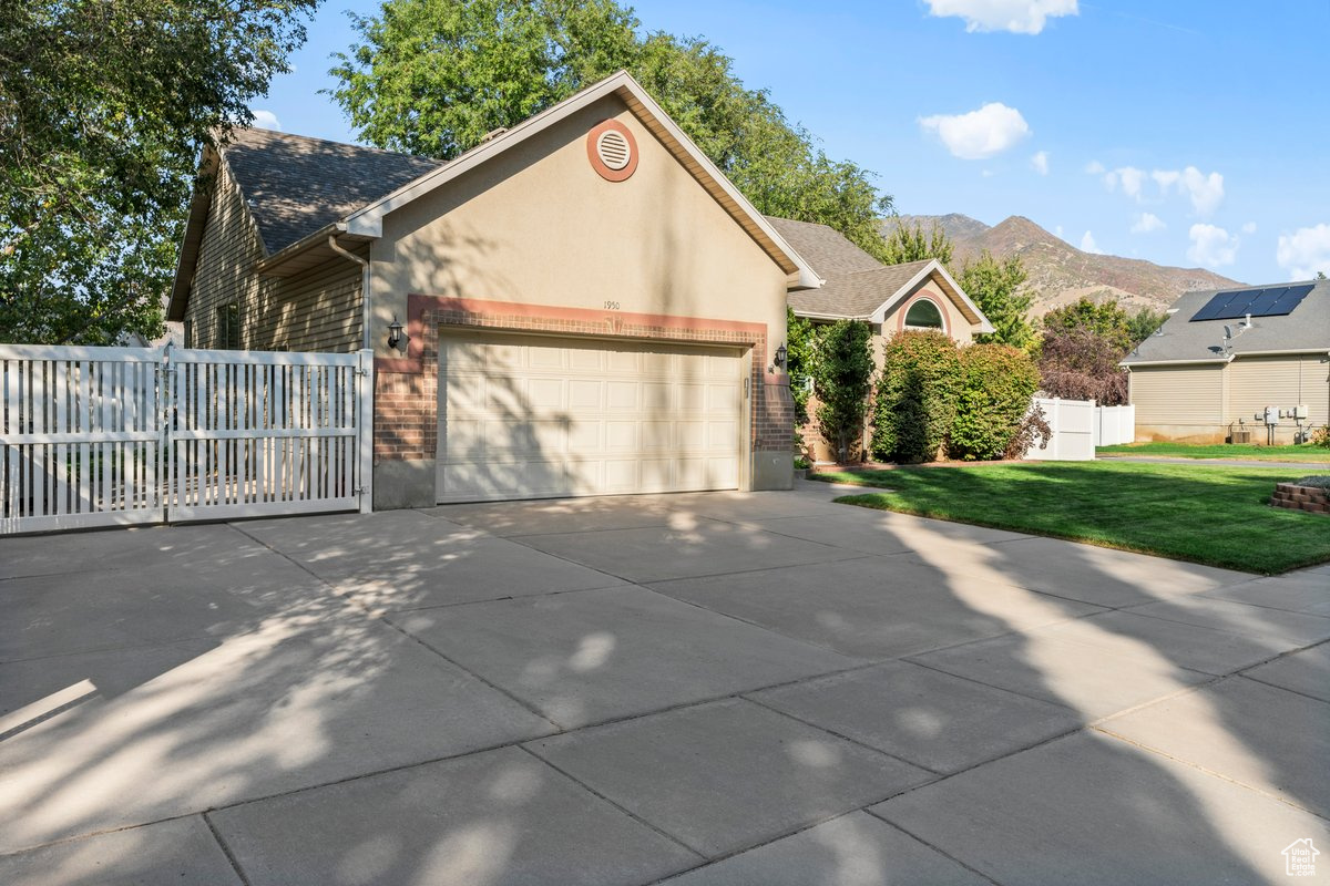 View of front facade featuring a mountain view, a front yard, and a garage