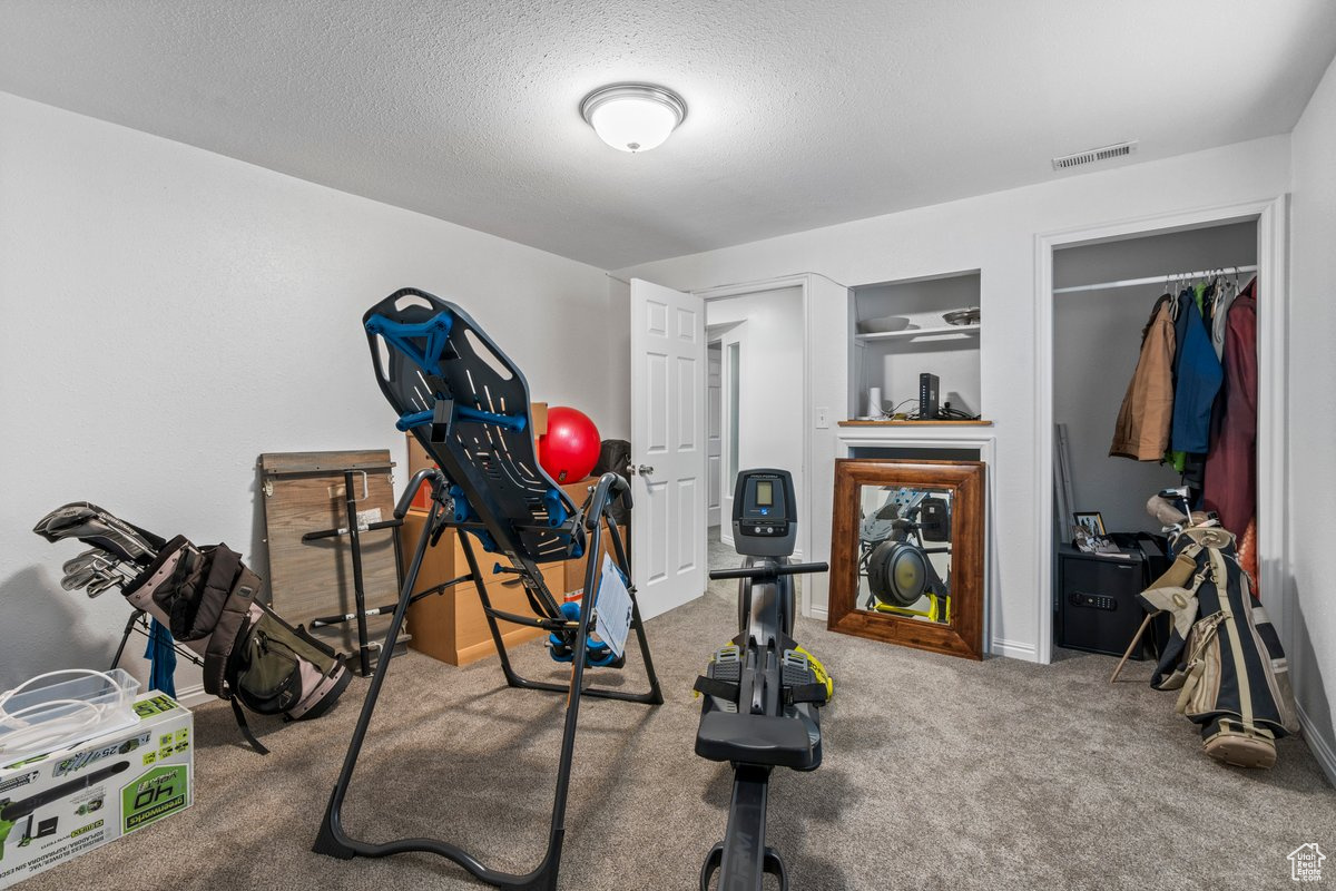 Workout room featuring carpet floors and a textured ceiling