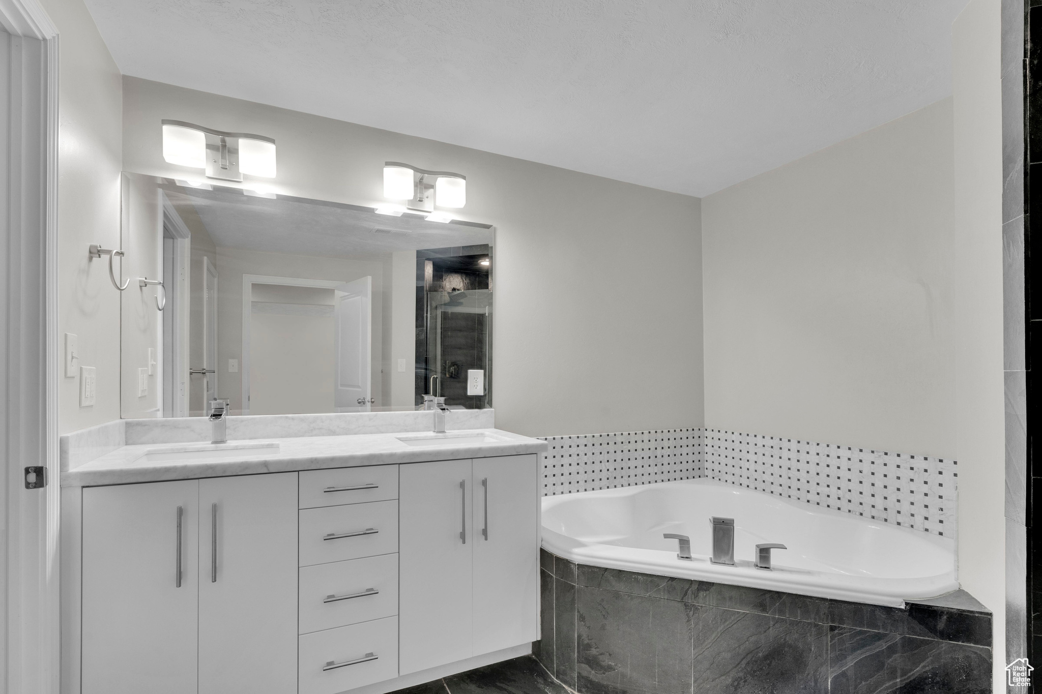 Master Bathroom with vanity and tiled bath