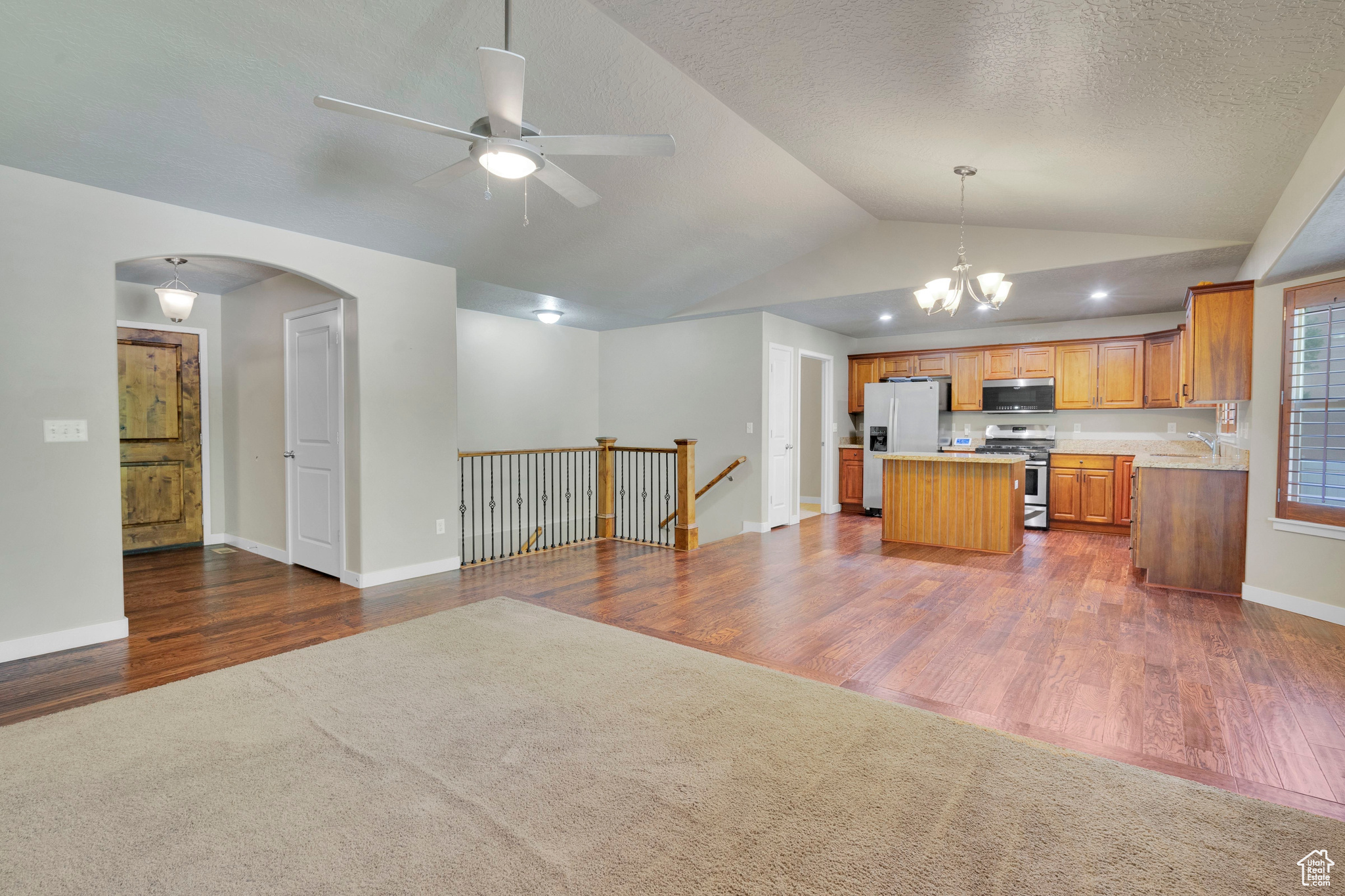 Kitchen featuring appliances with stainless steel finishes, lofted ceiling, and dark hardwood / wood-style floors