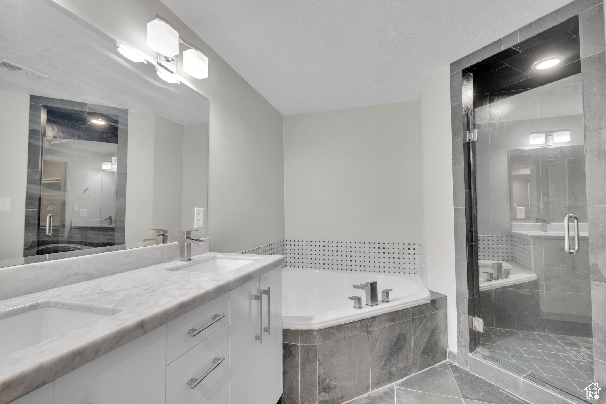 Master Bathroom featuring vanity, plus walk in shower, and tile patterned flooring