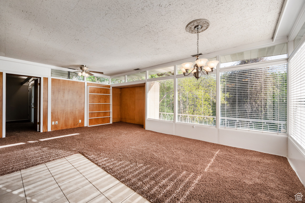 Interior space with ceiling fan with notable chandelier