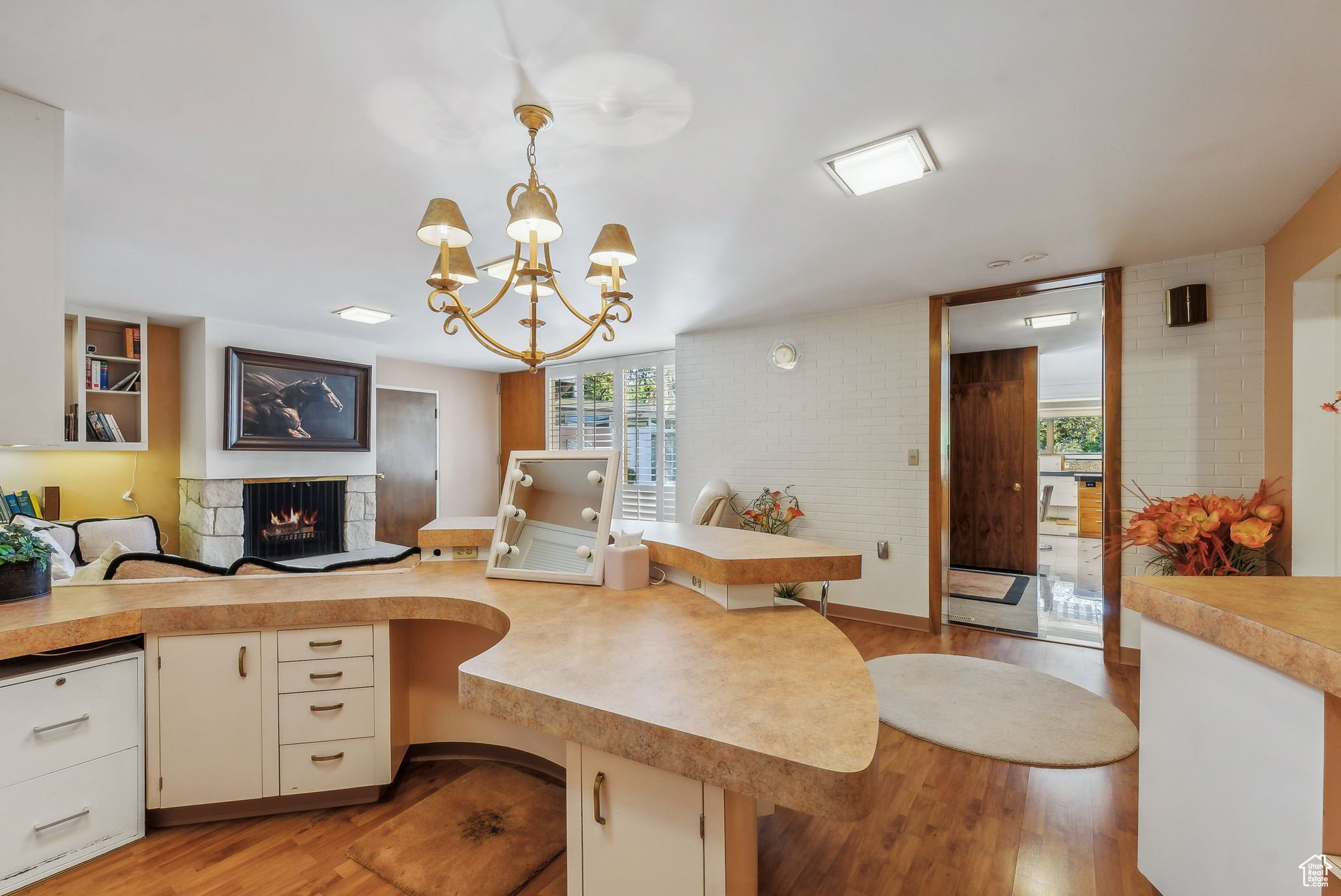 Kitchen featuring kitchen peninsula, a bar, pendant lighting, and light hardwood / wood-style floors