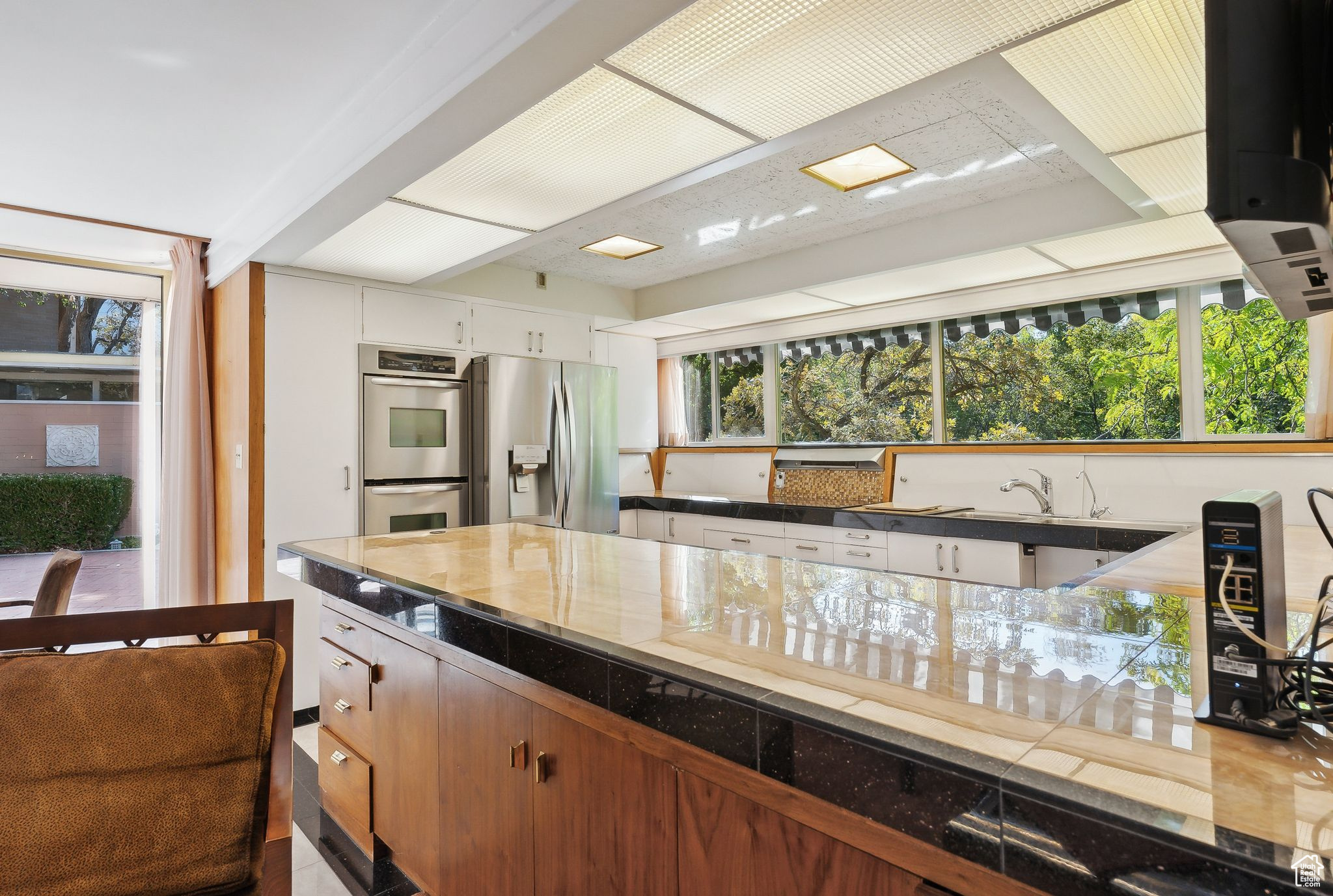 Kitchen featuring white cabinetry, stainless steel appliances, and plenty of natural light