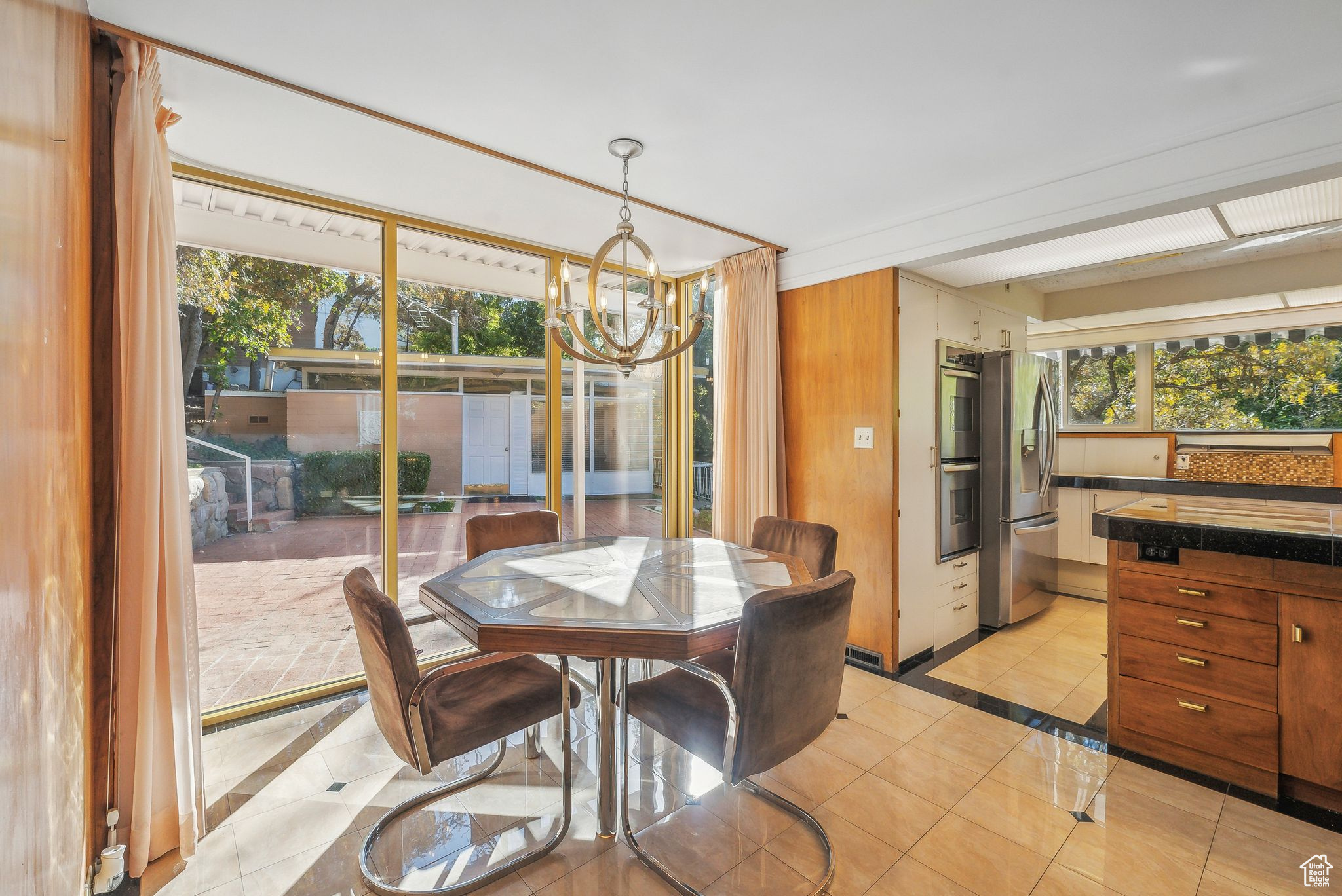 Dining space with light tile patterned flooring, a chandelier, and plenty of natural light