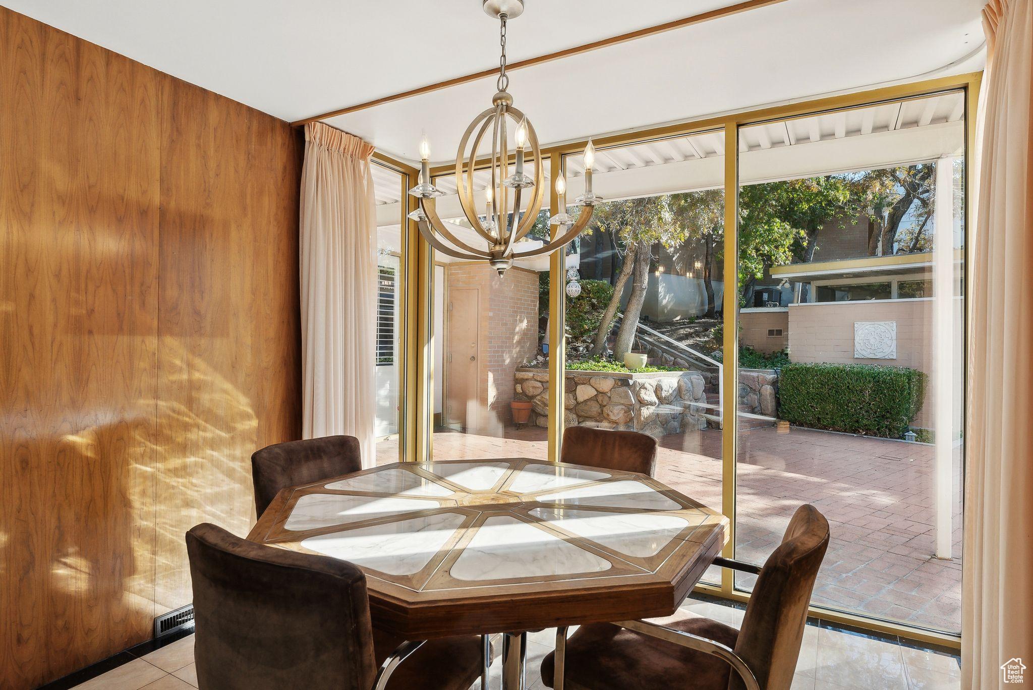 Dining area with walnut  walls and a notable chandelier