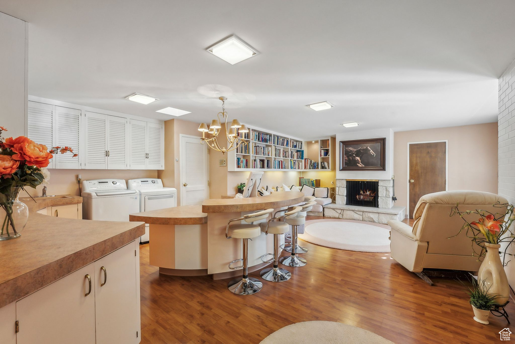 Decorative light fixtures, an inviting chandelier, washer and dryer, and dark hardwood / wood-style flooring