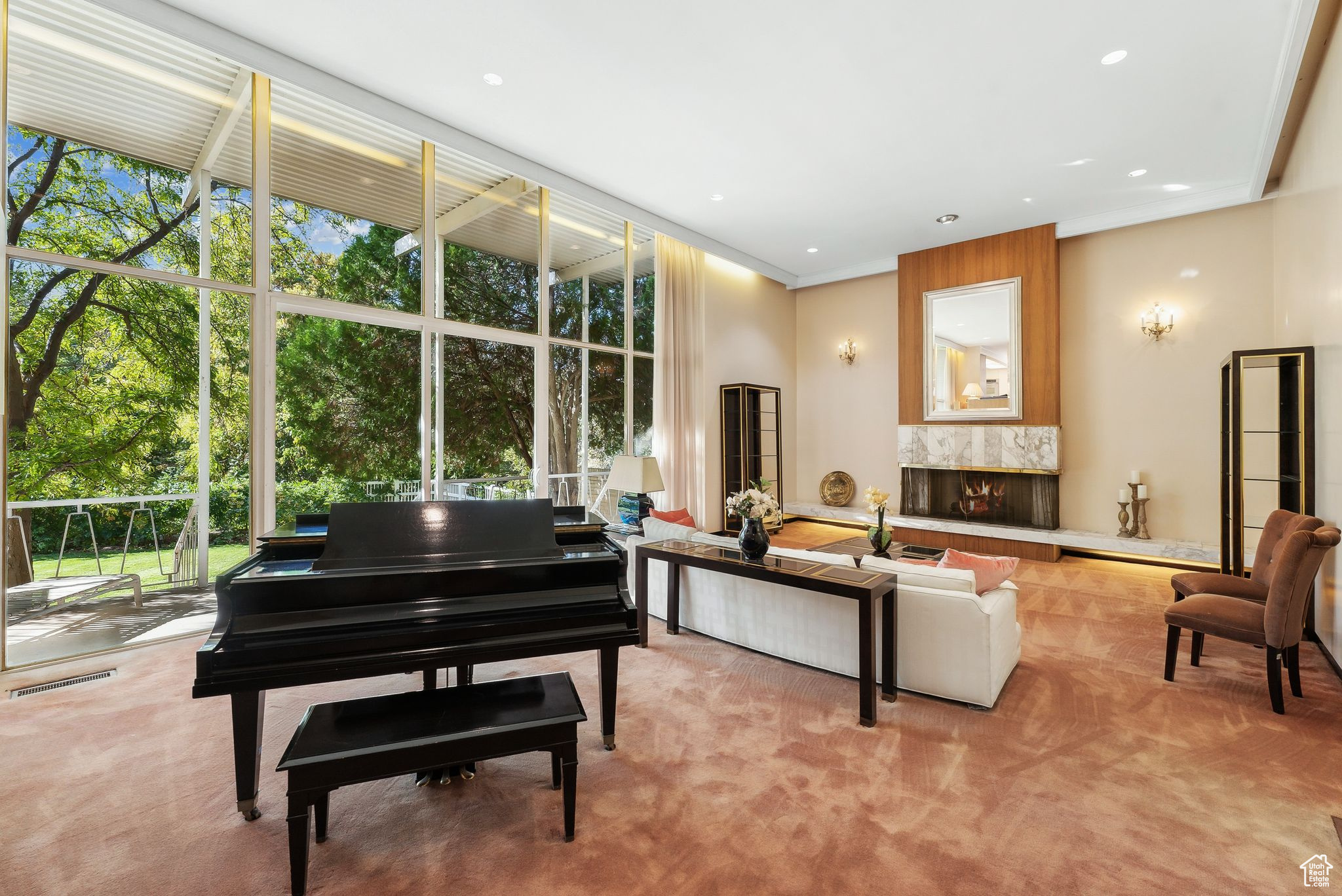 Miscellaneous room featuring ornamental molding, a wall of windows, a high end fireplace, and light colored carpet