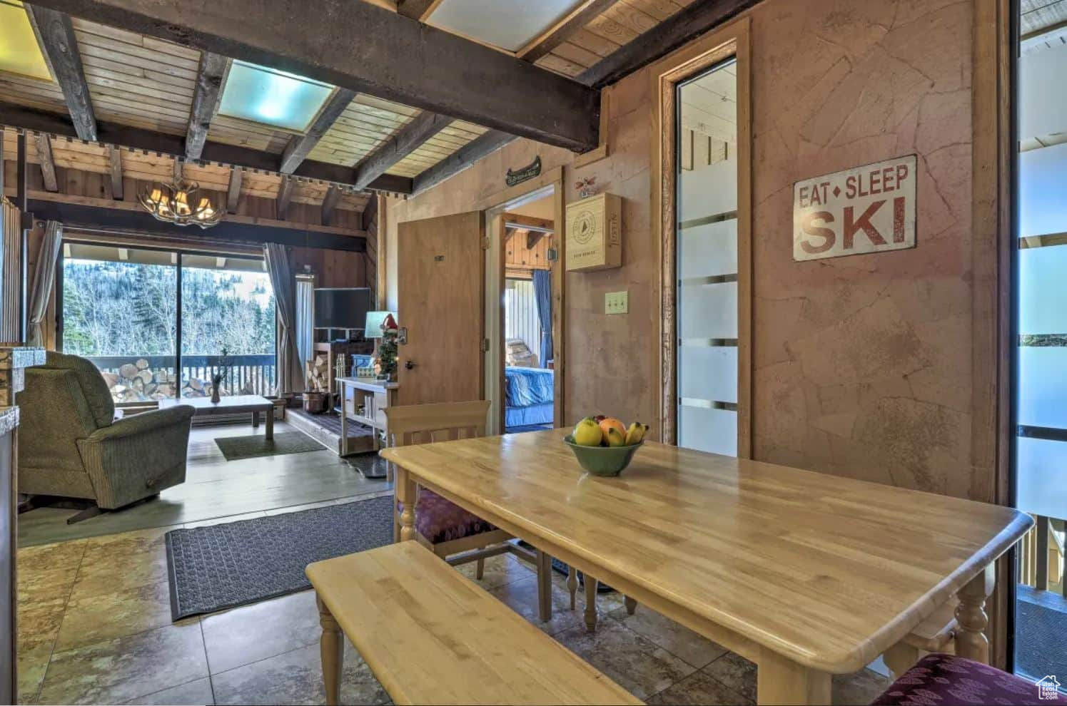 Dining room featuring a notable chandelier, wooden walls, beam ceiling, and wooden ceiling