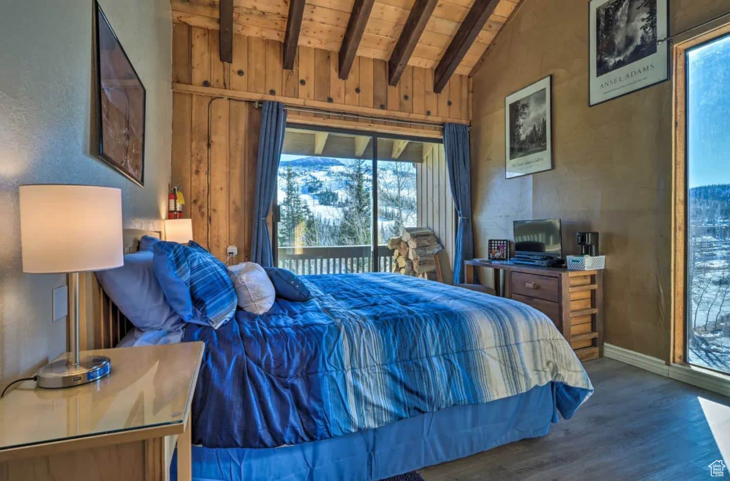 Bedroom featuring lofted ceiling with beams, multiple windows, access to outside, and dark hardwood / wood-style flooring