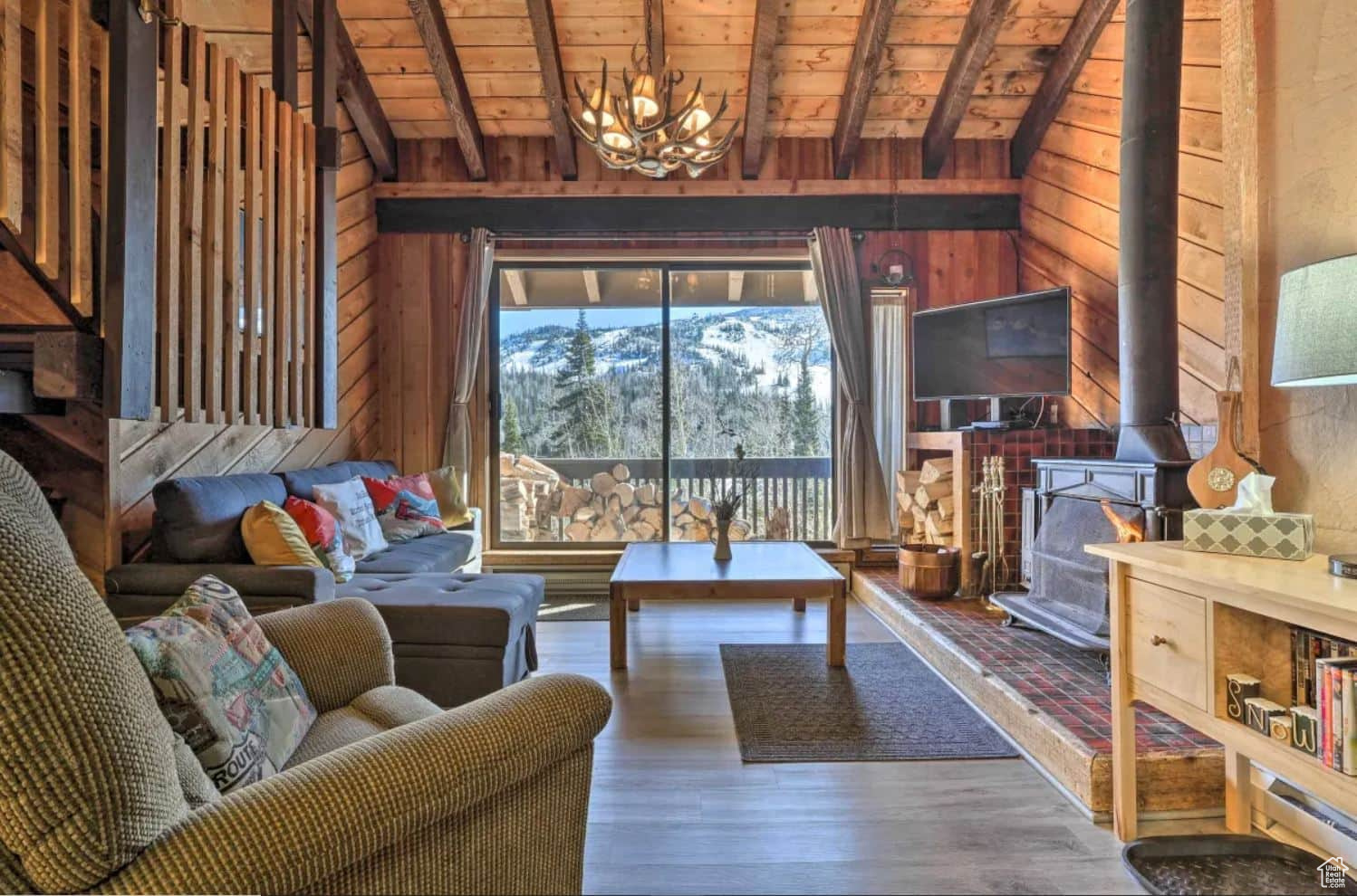 Living room with vaulted ceiling with beams, hardwood / wood-style flooring, wood walls, and wooden ceiling