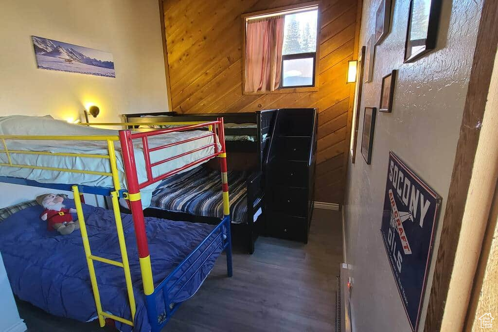 Bedroom featuring wood walls and wood-type flooring