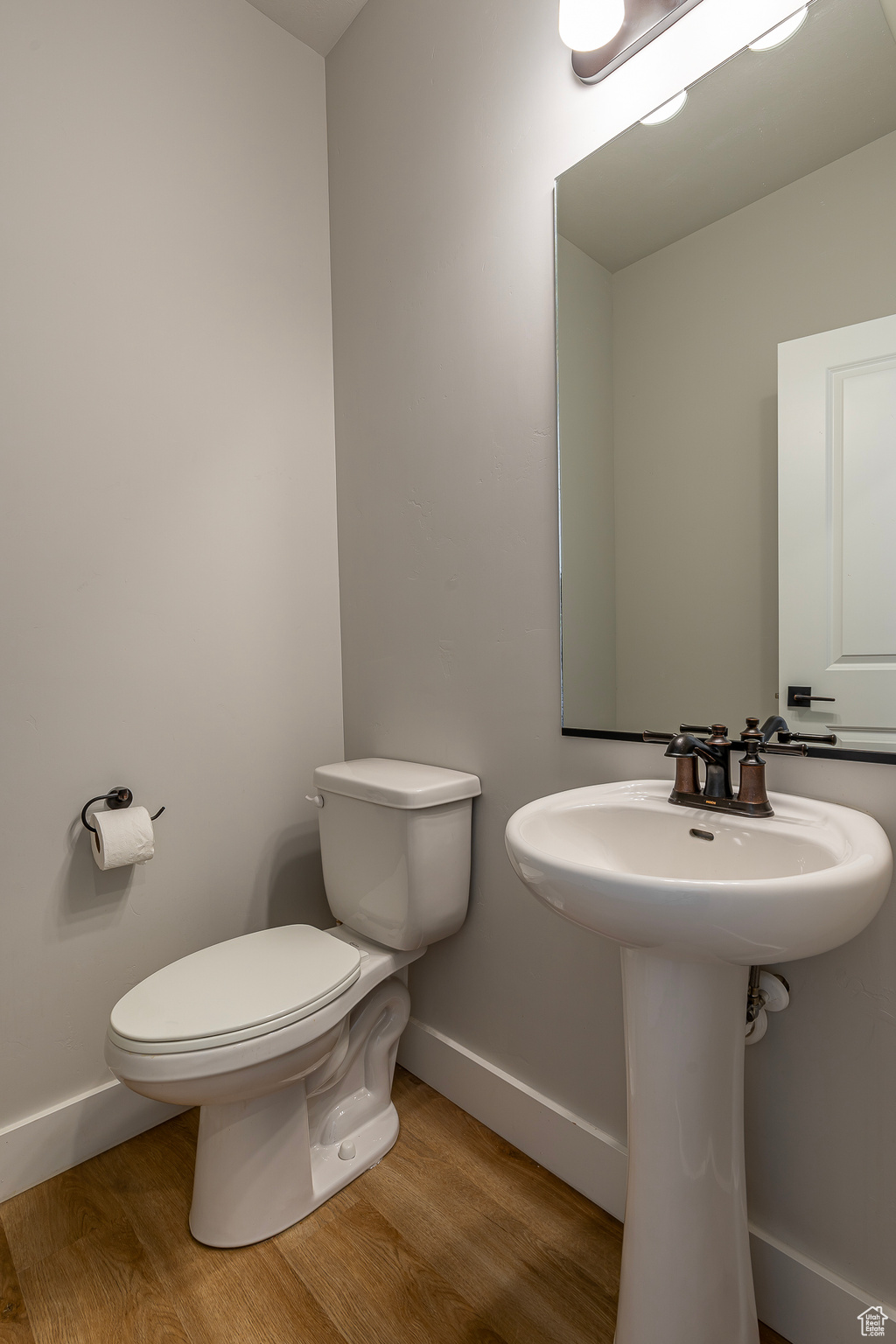 Bathroom featuring toilet, hardwood / wood-style flooring, and sink