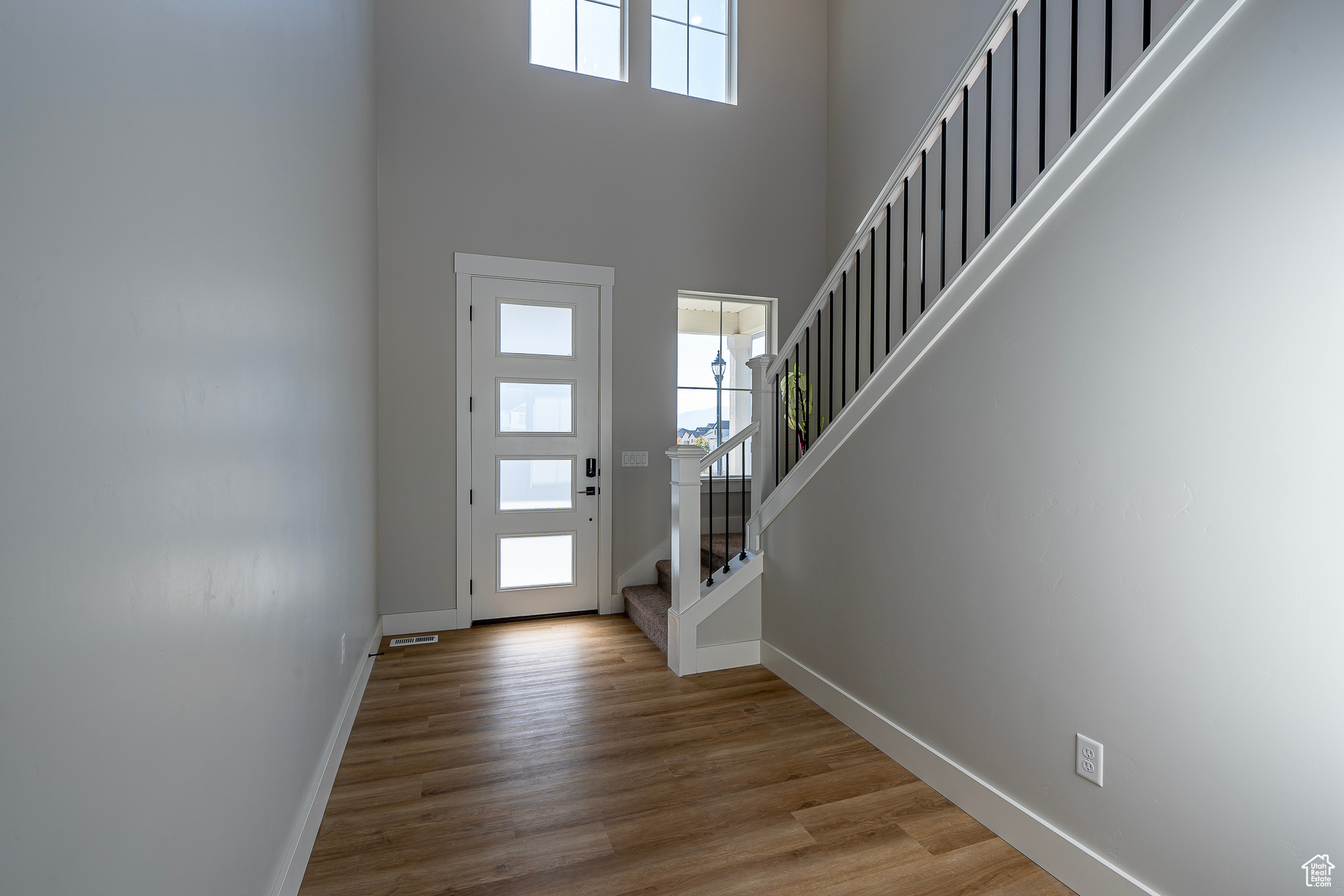 Entrance foyer with a towering ceiling and light wood-type flooring