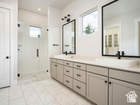 Bathroom featuring vanity and a shower with door