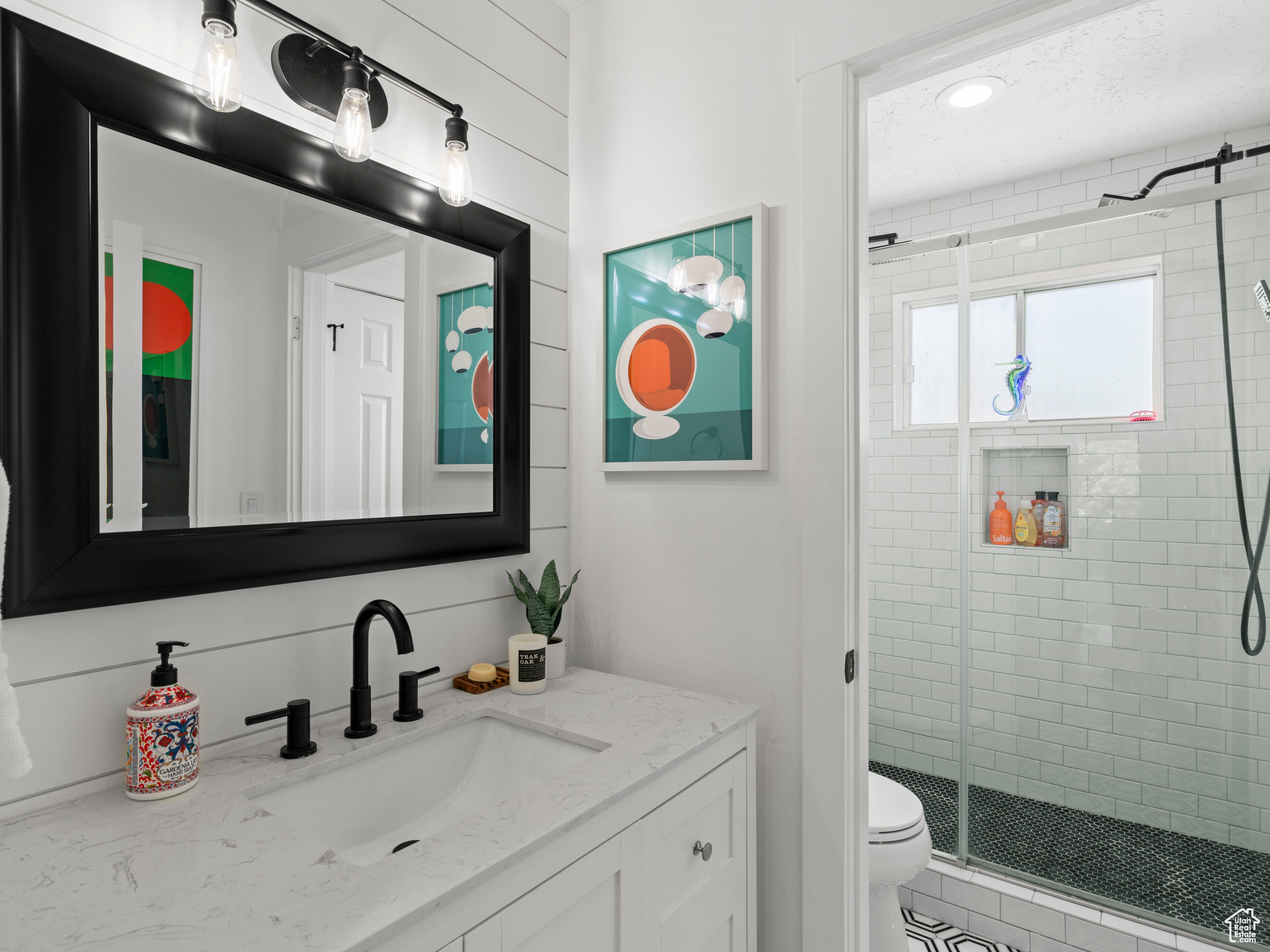 Bathroom featuring vanity, toilet, and an enclosed shower