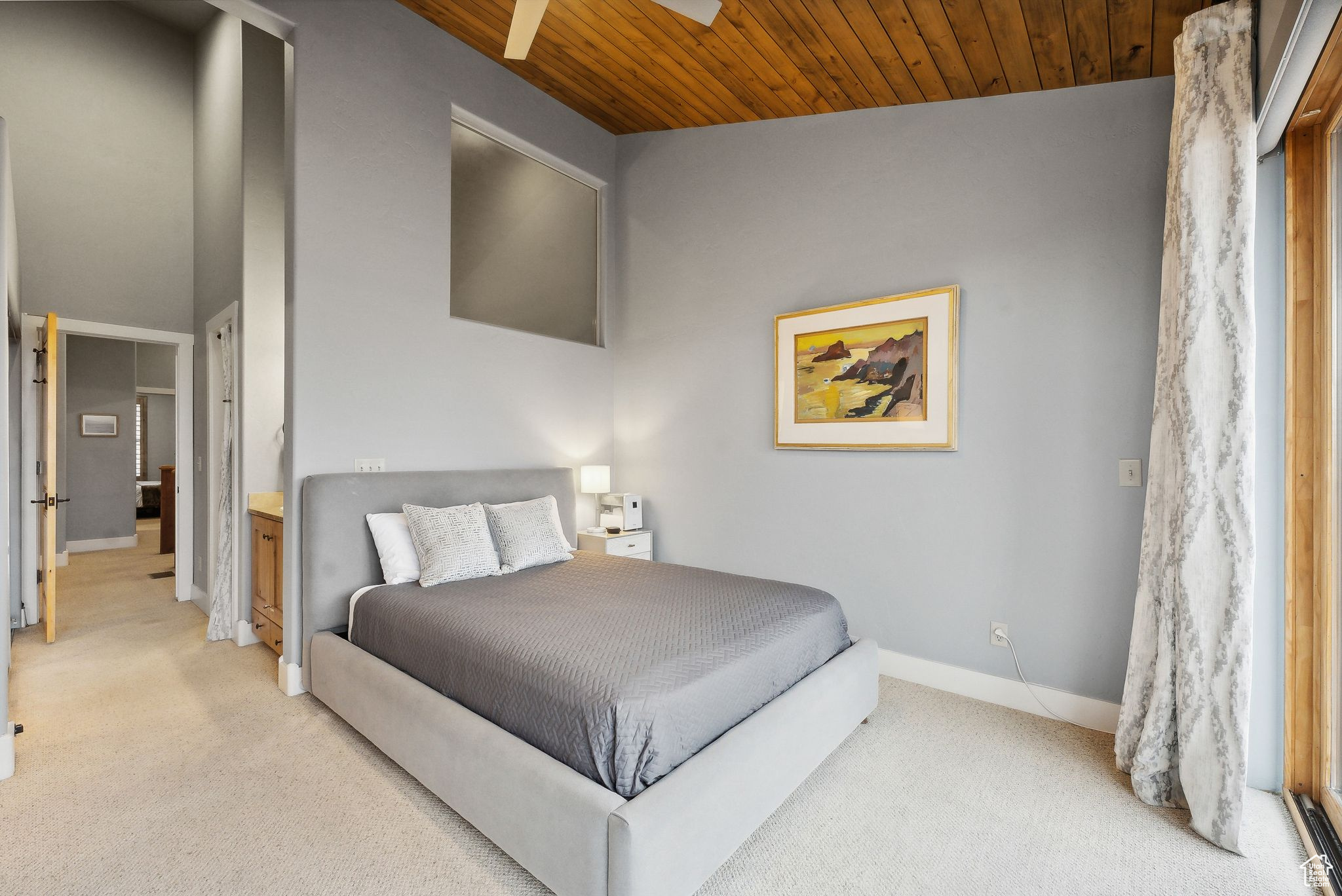 Carpeted bedroom with high vaulted ceiling, wooden ceiling, and ceiling fan