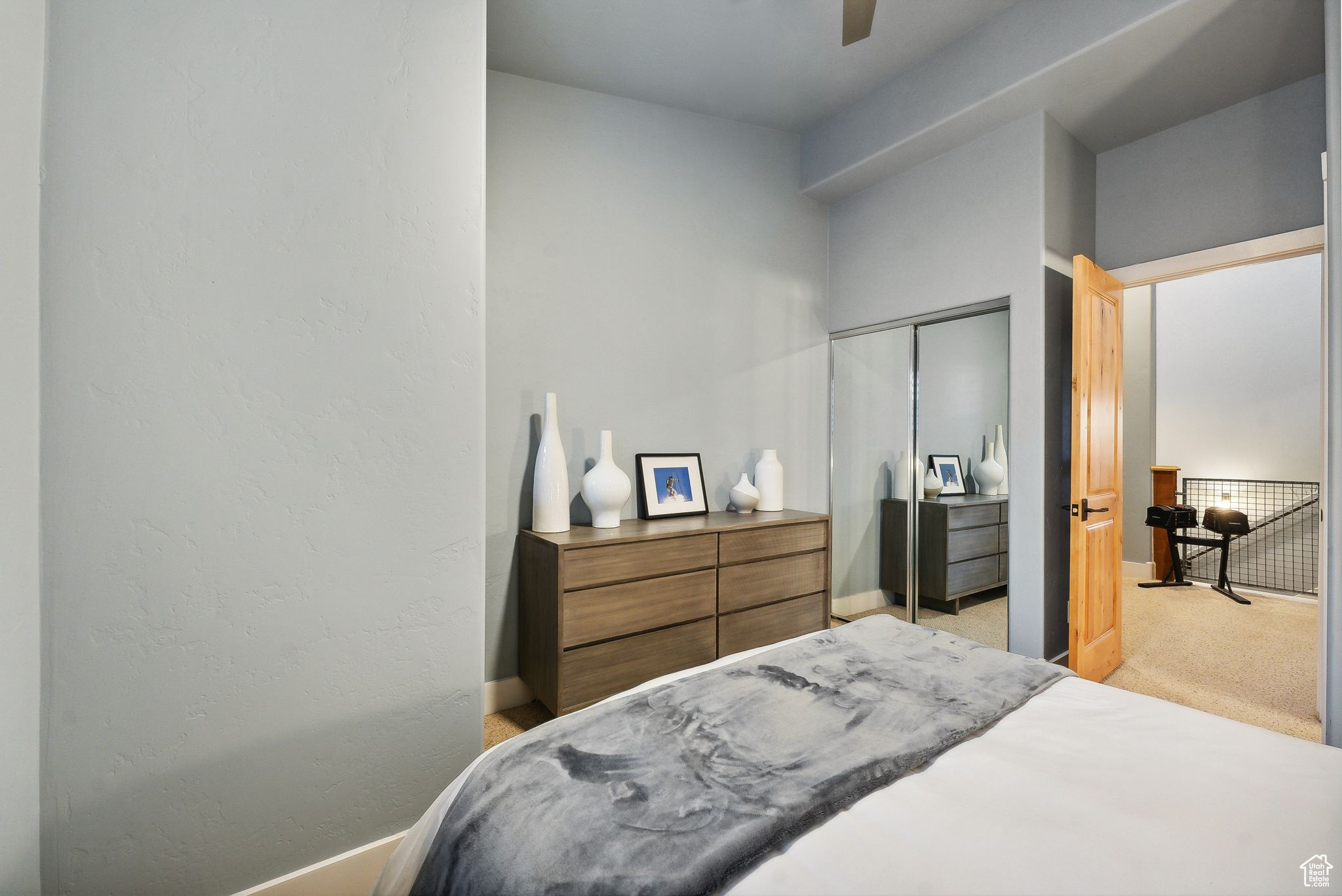 Bedroom featuring a closet, light colored carpet, and ceiling fan