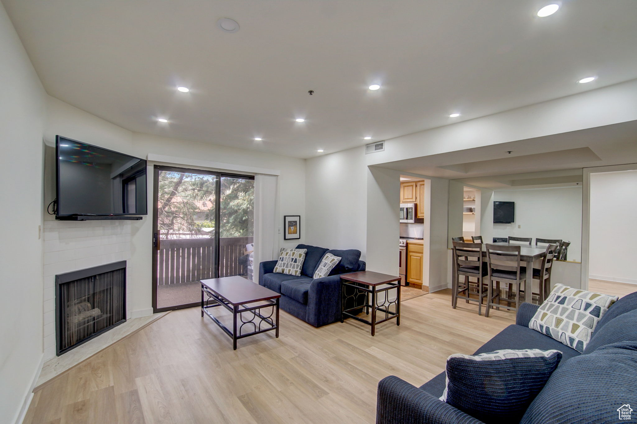 Living room featuring light wood-type flooring and a tiled fireplace