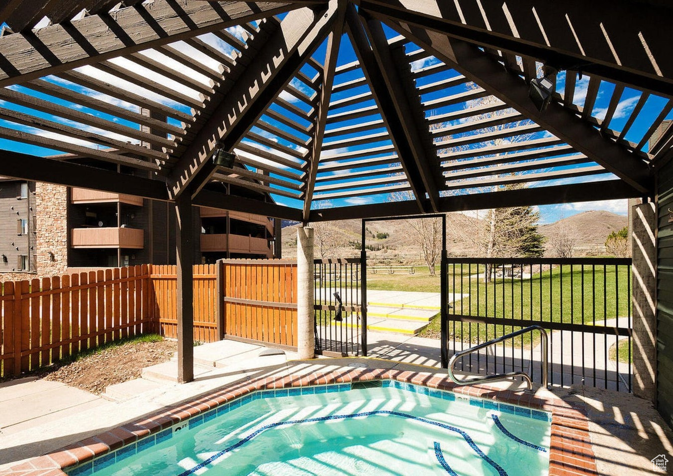 View of swimming pool featuring a pergola, a mountain view, a lawn, and a patio area