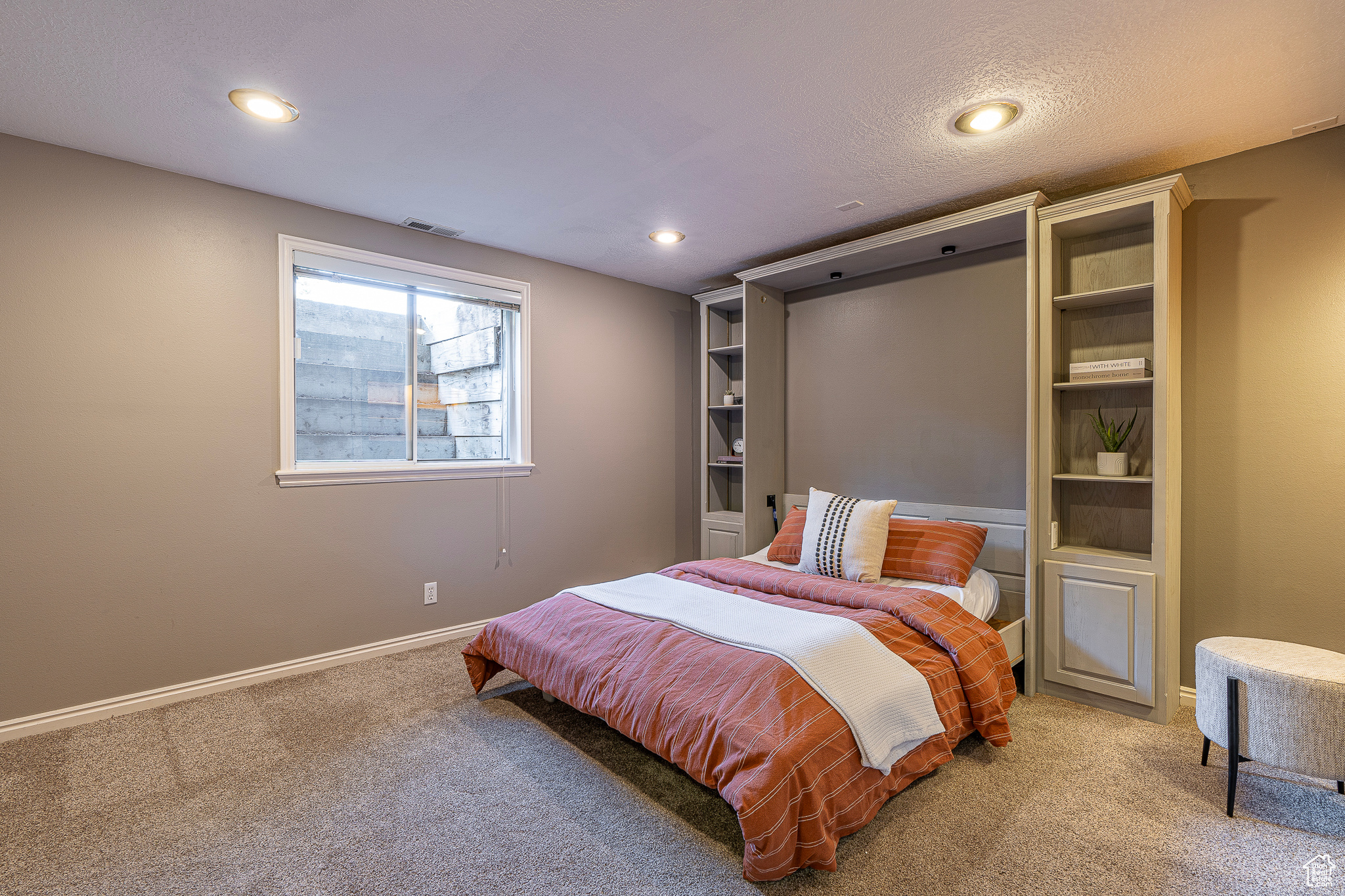 Carpeted bedroom with a textured ceiling