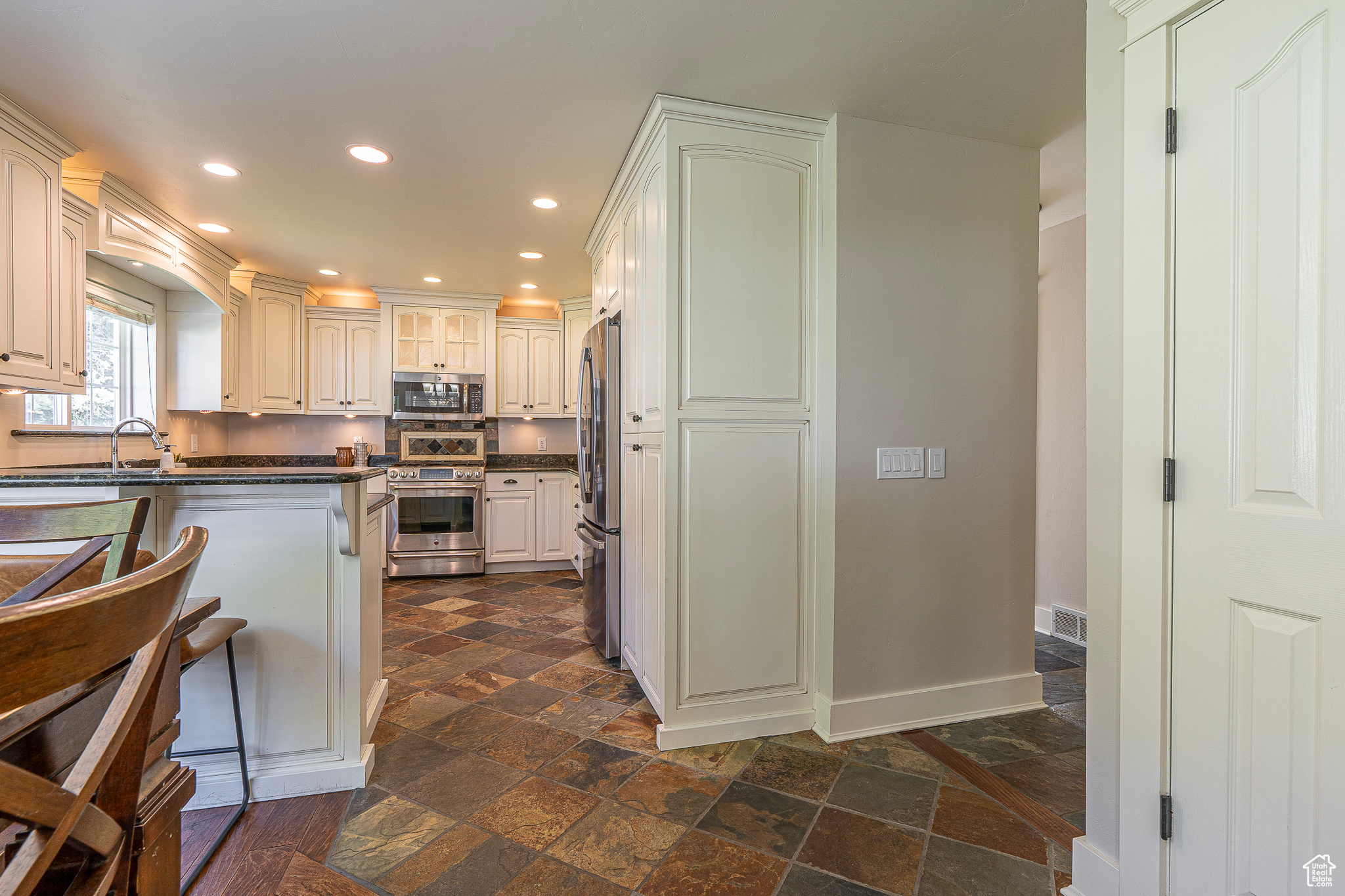 Kitchen with appliances with stainless steel finishes, white cabinets, and sink