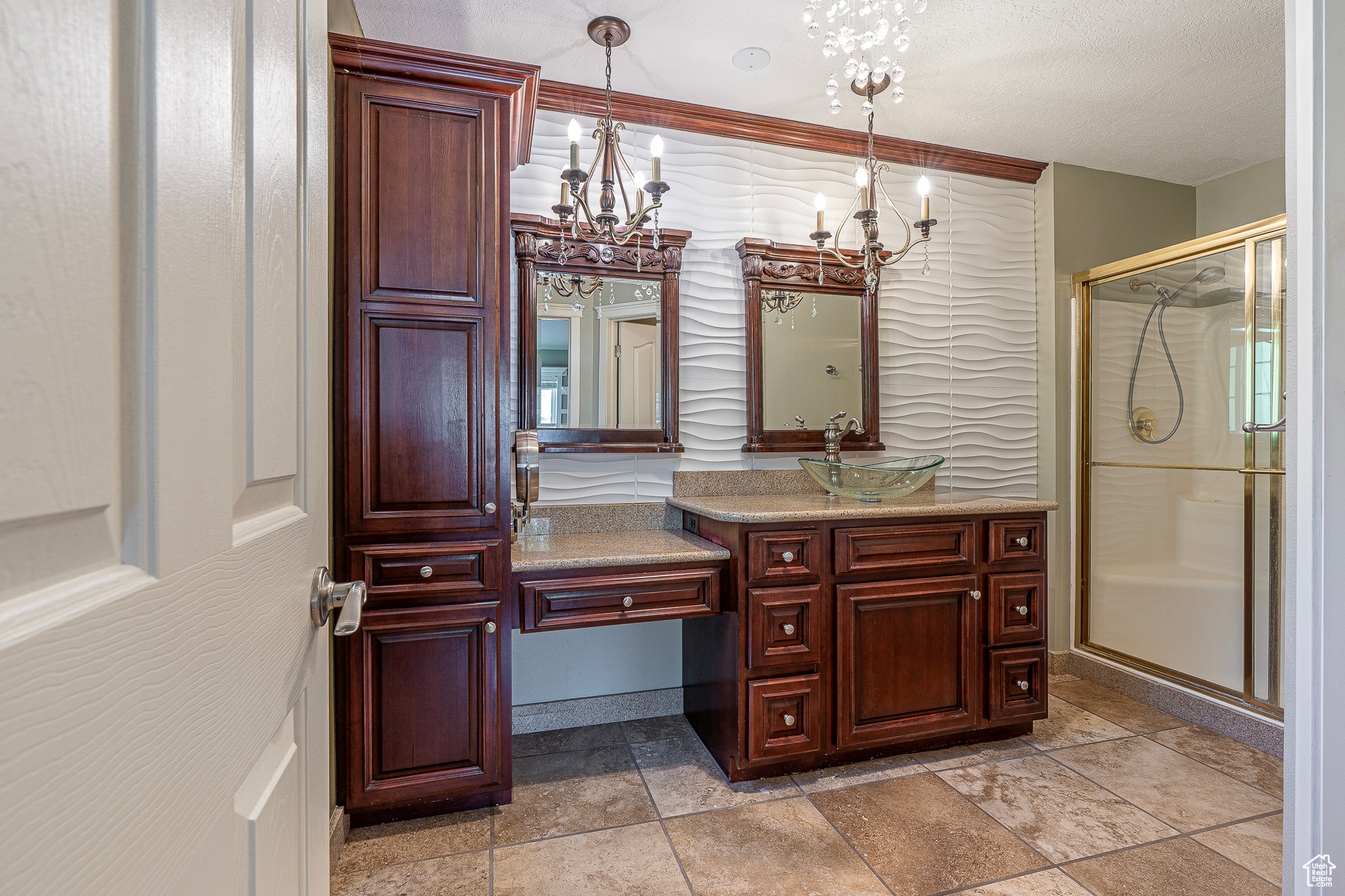 Bathroom with vanity, a textured ceiling, a chandelier, and a shower with shower door