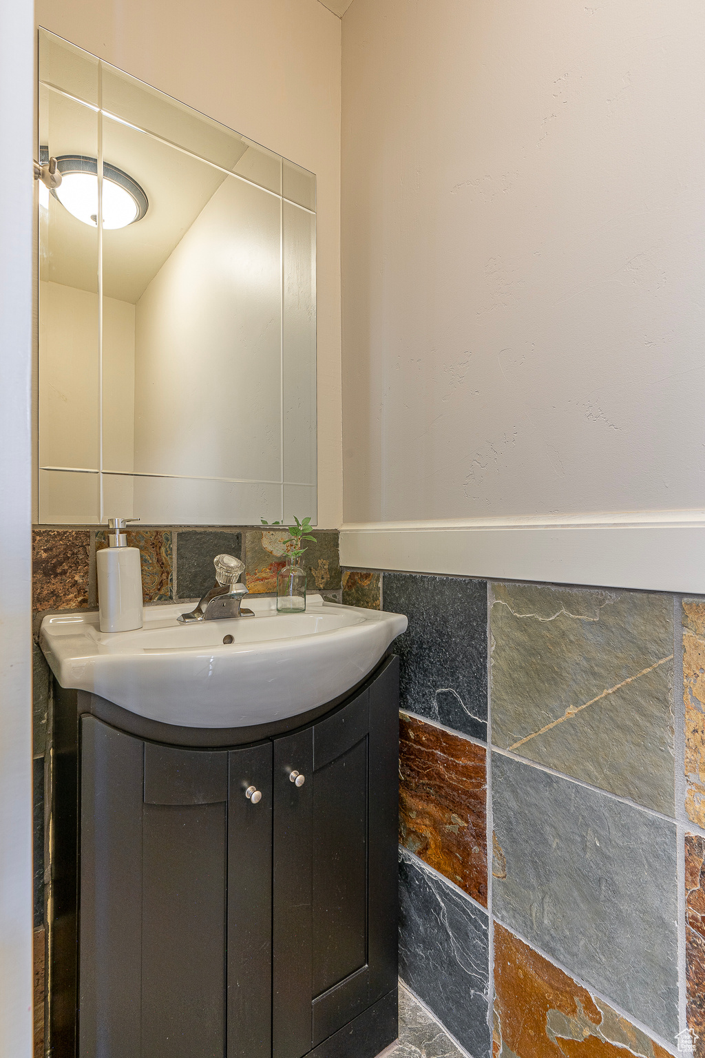 Bathroom featuring vanity and tile walls