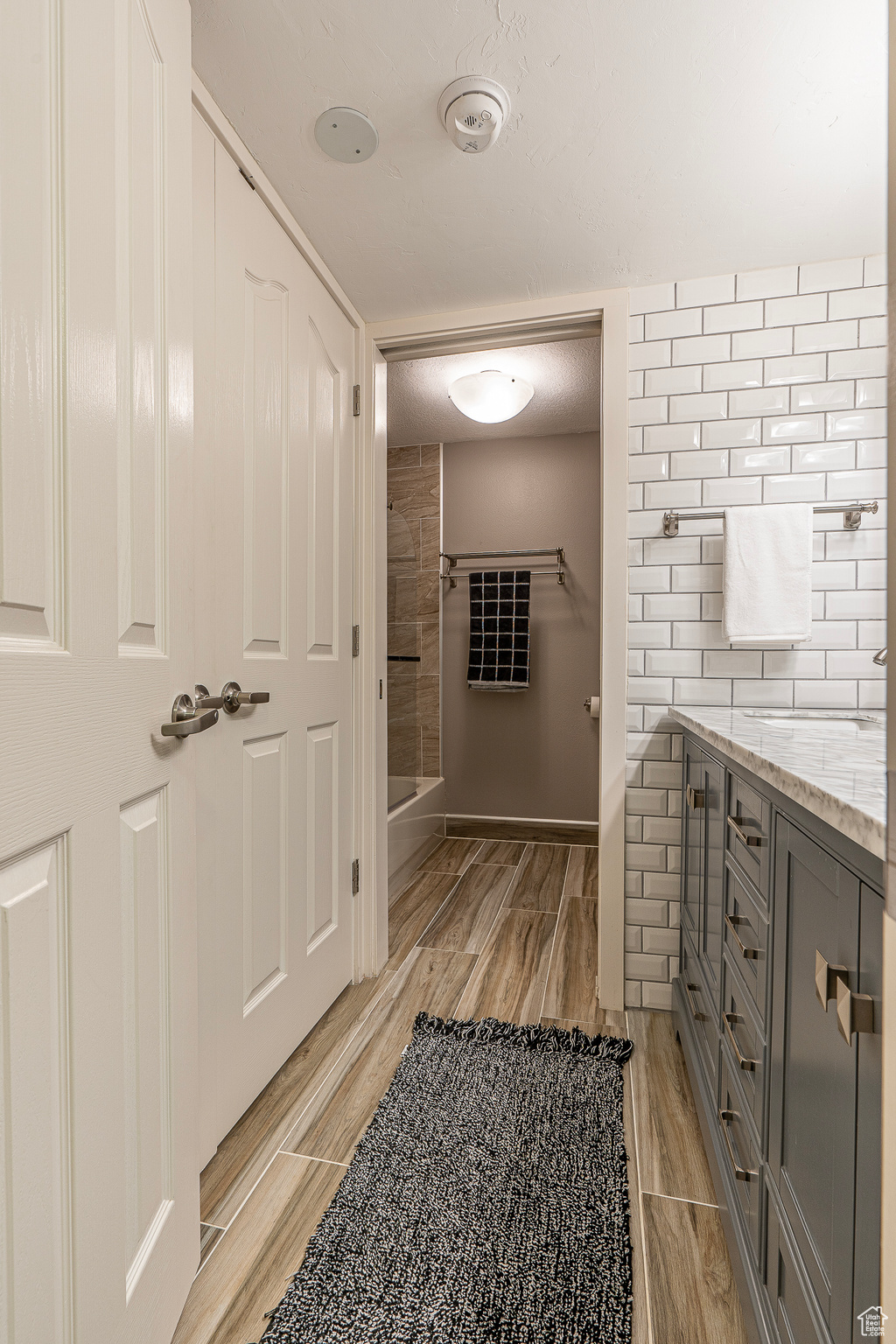 Bathroom featuring vanity, a textured ceiling, hardwood / wood-style flooring, and a shower