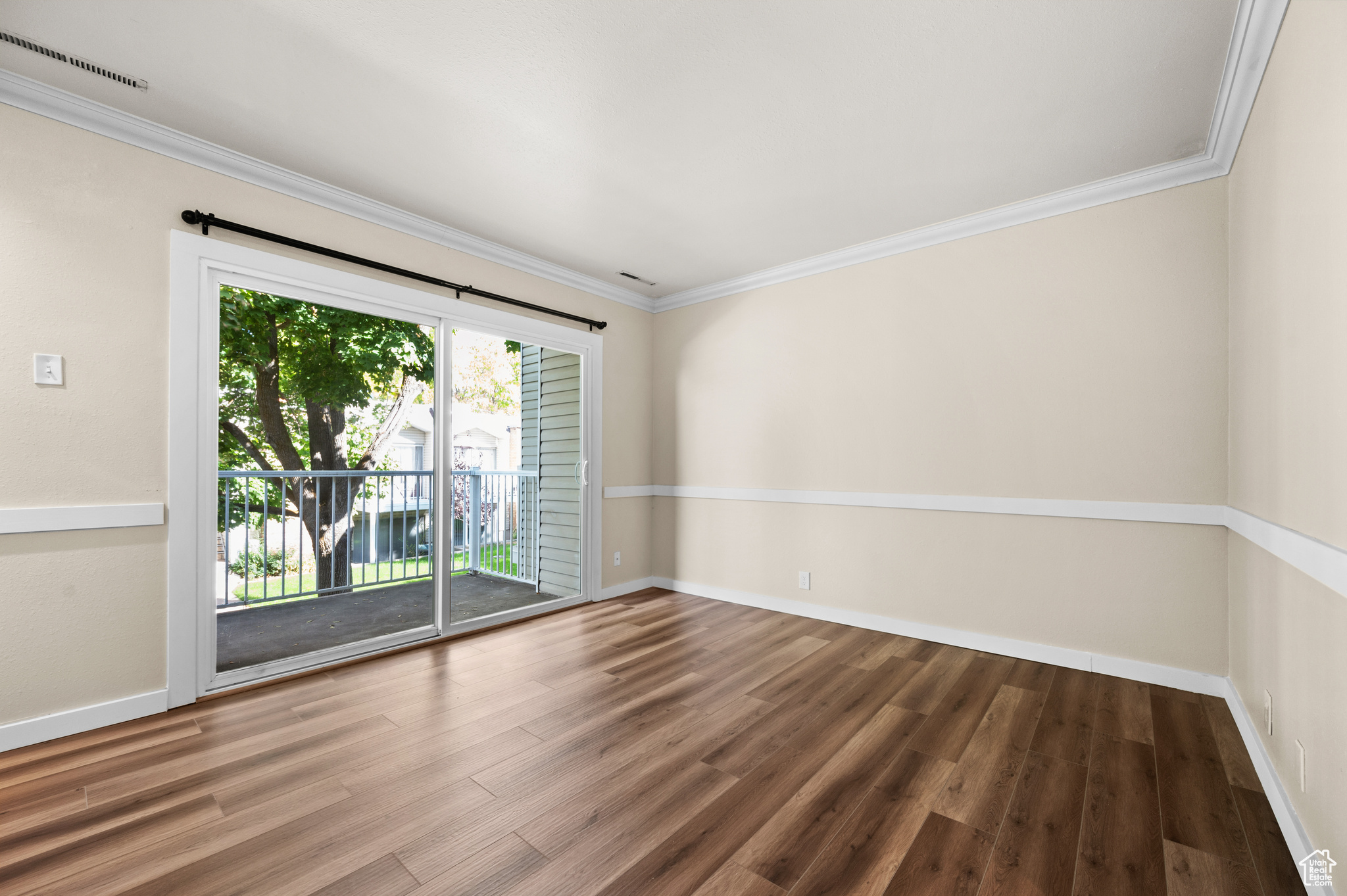 Spare room featuring crown molding and wood-type flooring