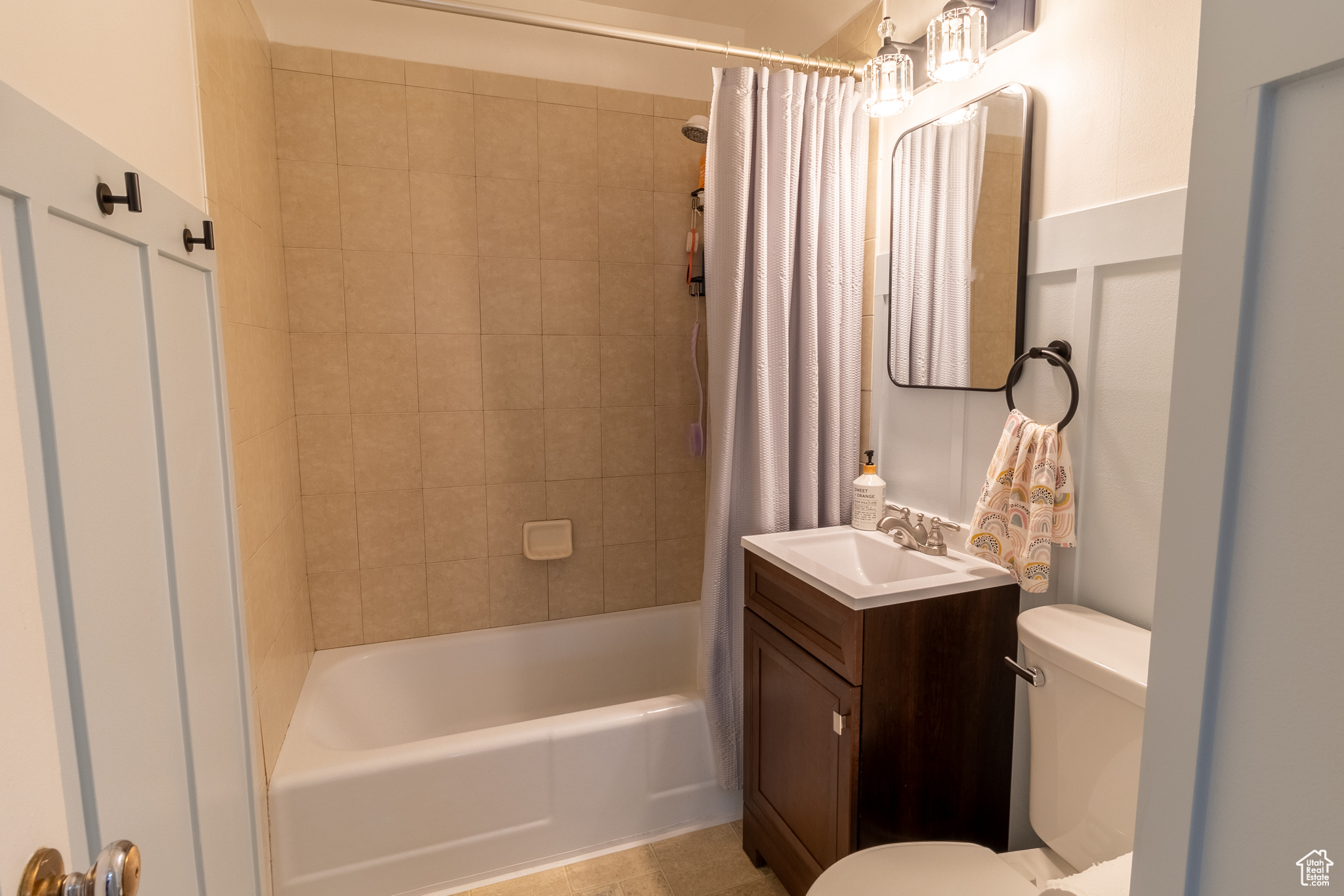 Full bathroom with vanity, shower / bath combo with shower curtain, and toilet