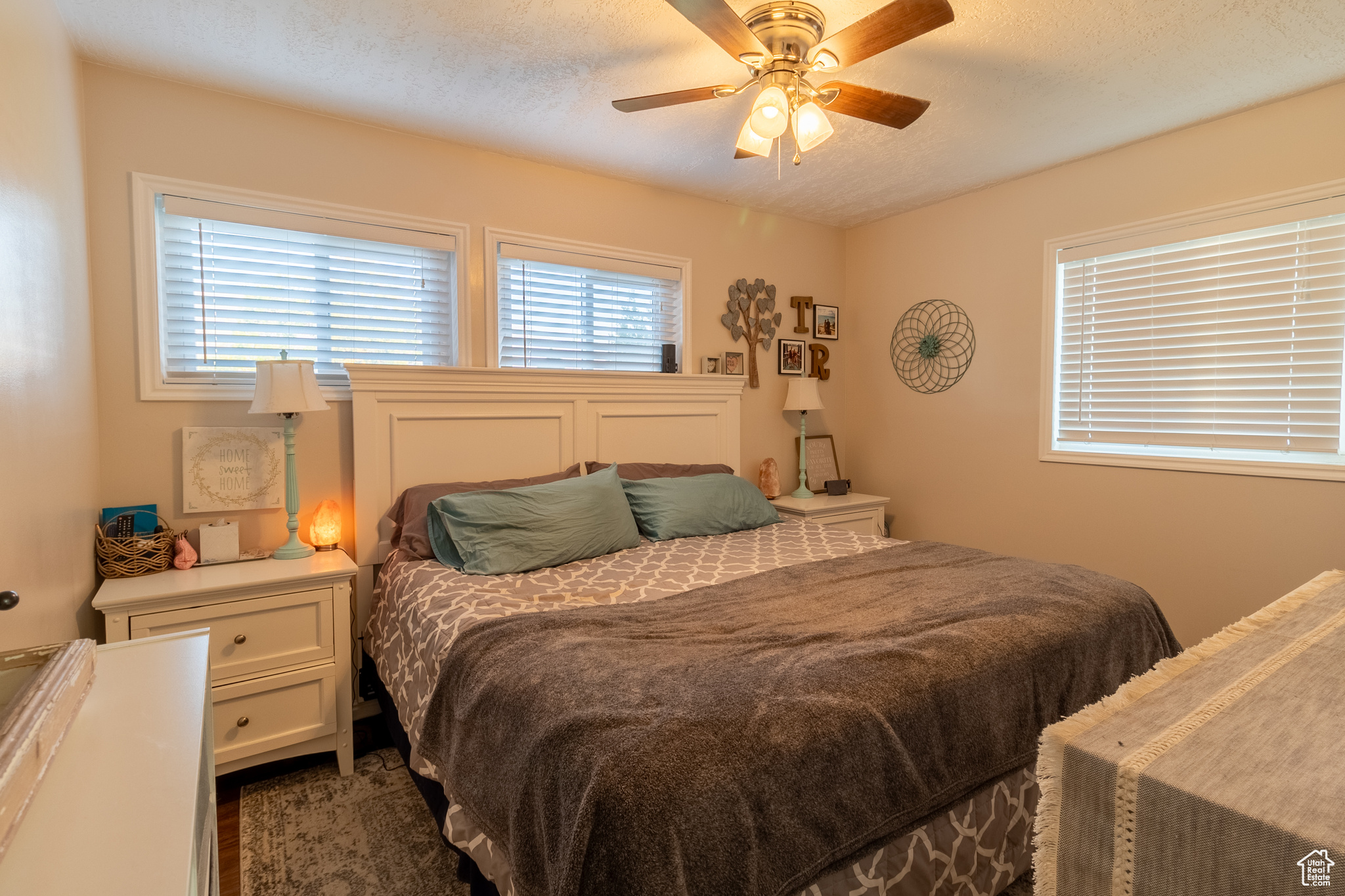 Bedroom with ceiling fan and a textured ceiling