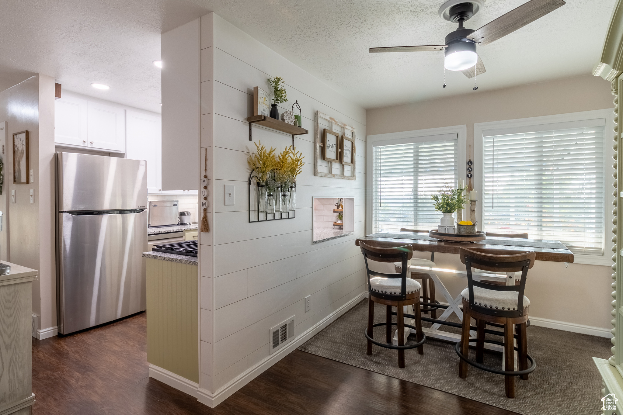 Dining room featuring ceiling fan, a textured ceiling, and dark hardwood / wood-style flooring