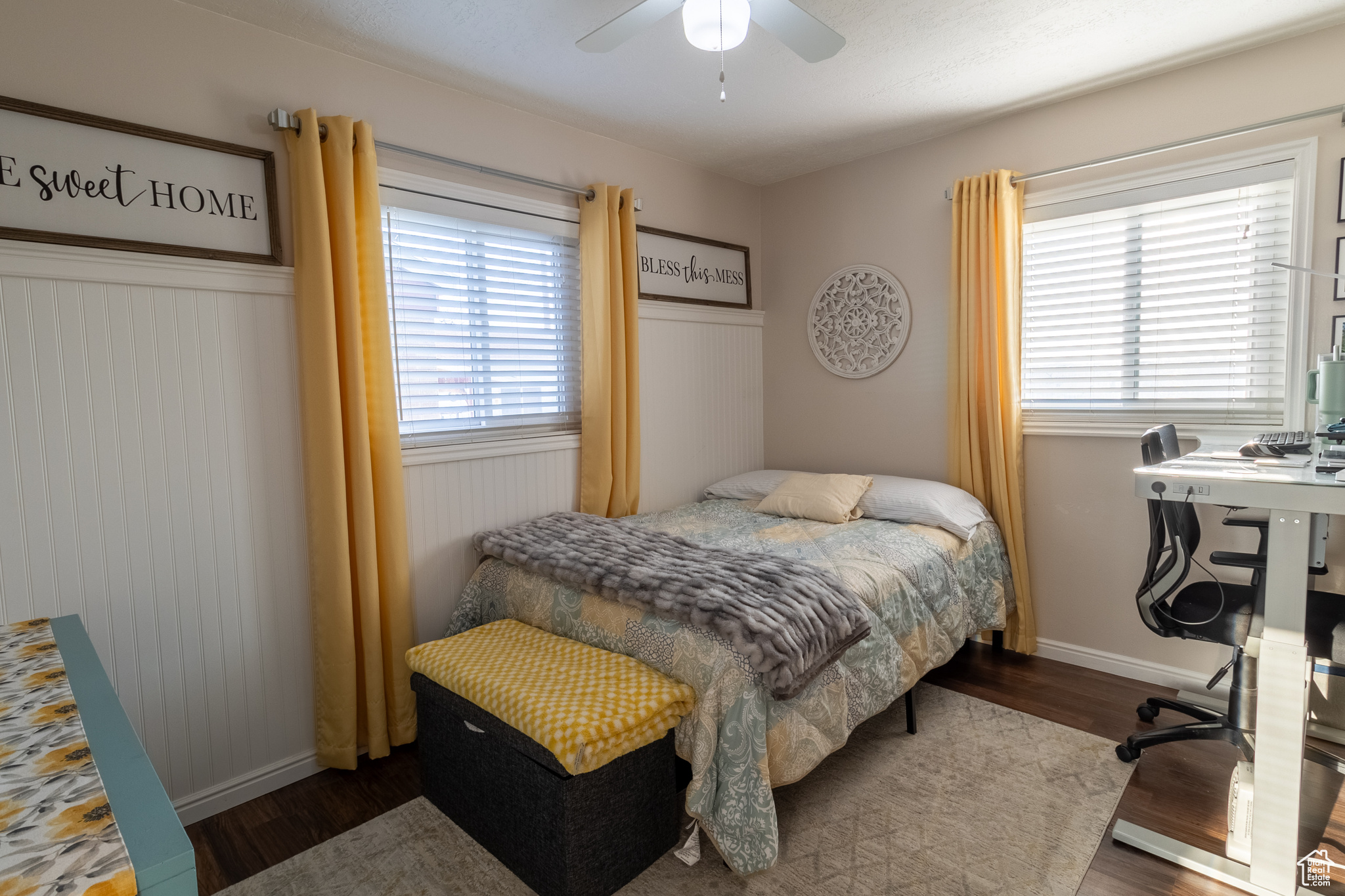 Bedroom with ceiling fan, hardwood / wood-style flooring, multiple windows, and wooden walls