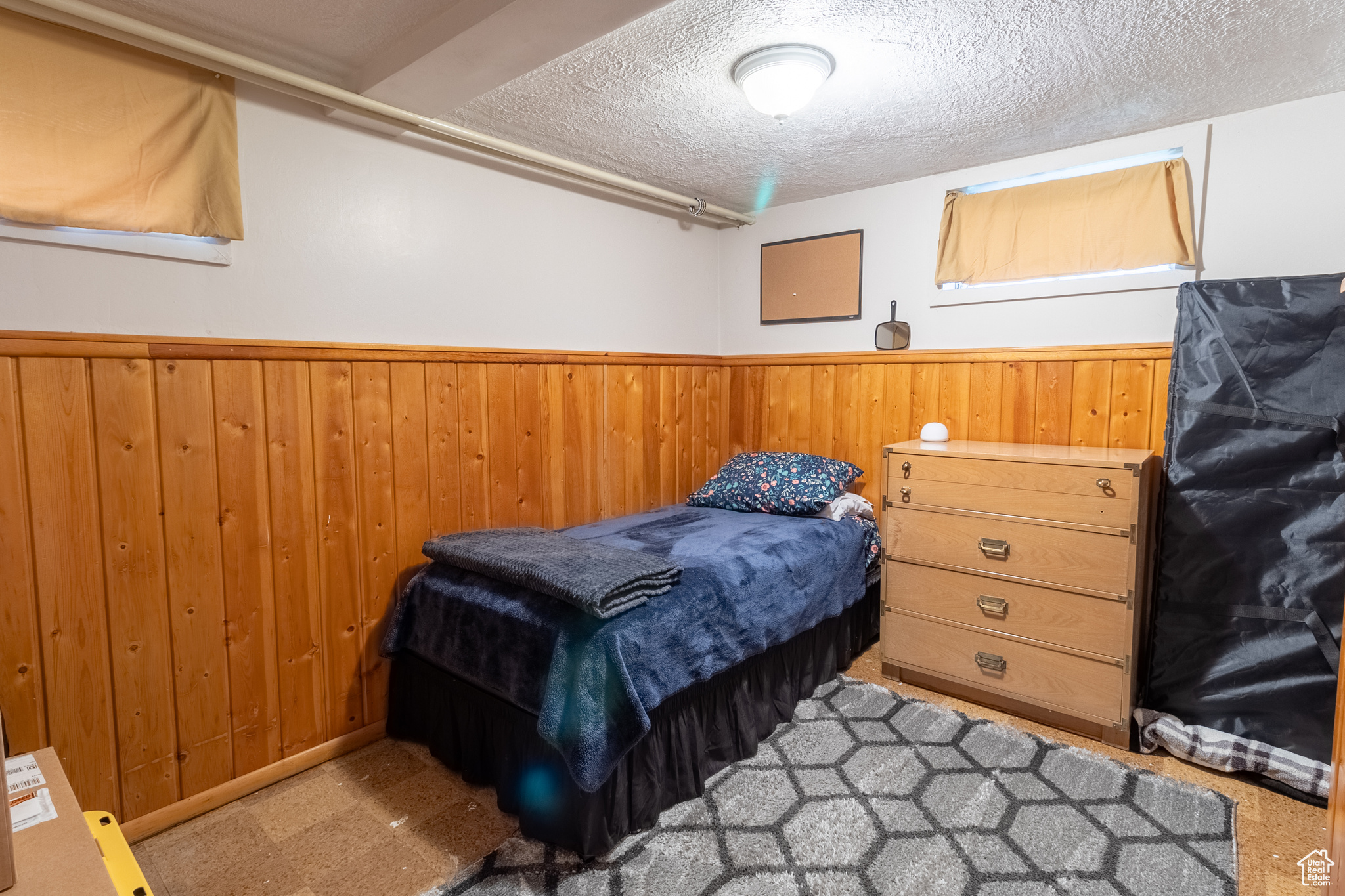 Bedroom with wood walls and a textured ceiling