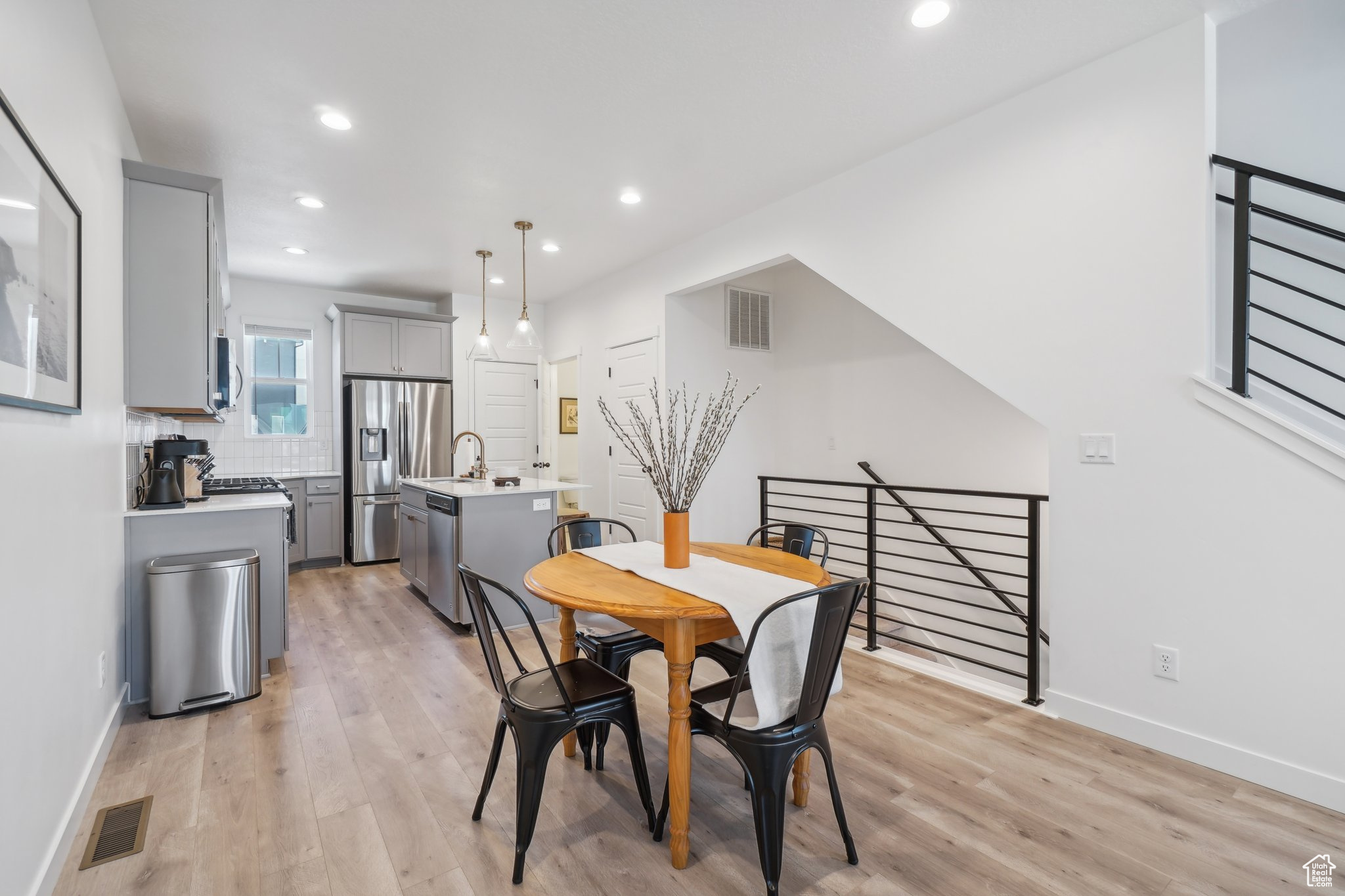 Dining area with sink and light wood-type flooring