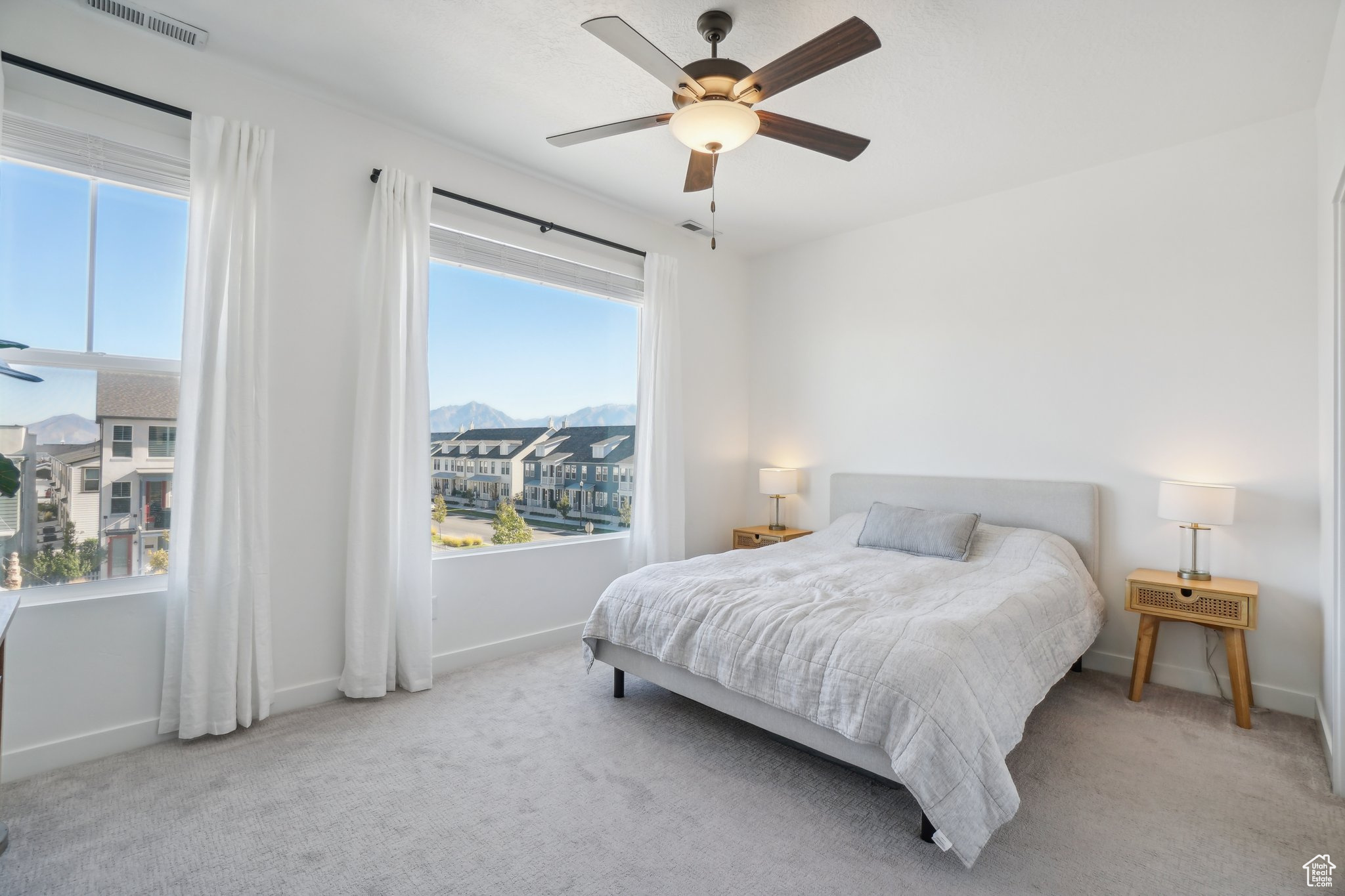 Carpeted bedroom with multiple windows, a mountain view, and ceiling fan