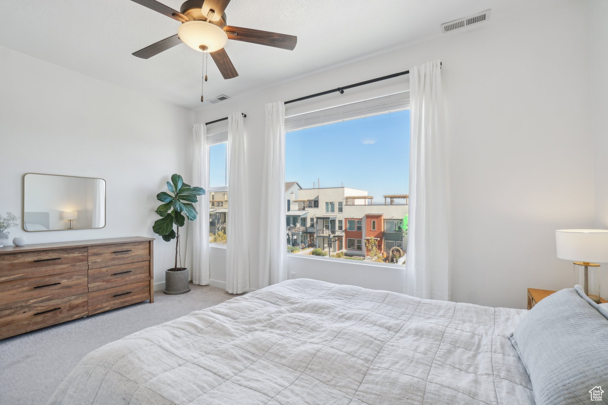 Carpeted bedroom with ceiling fan