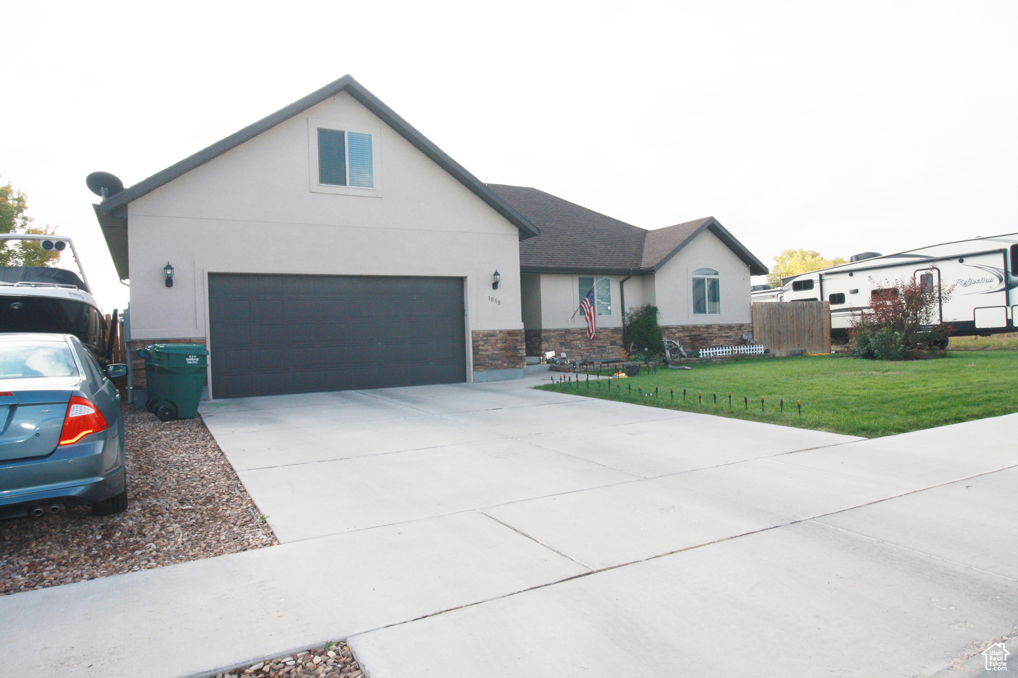 View of front facade featuring a front yard, a garage and RV parking.