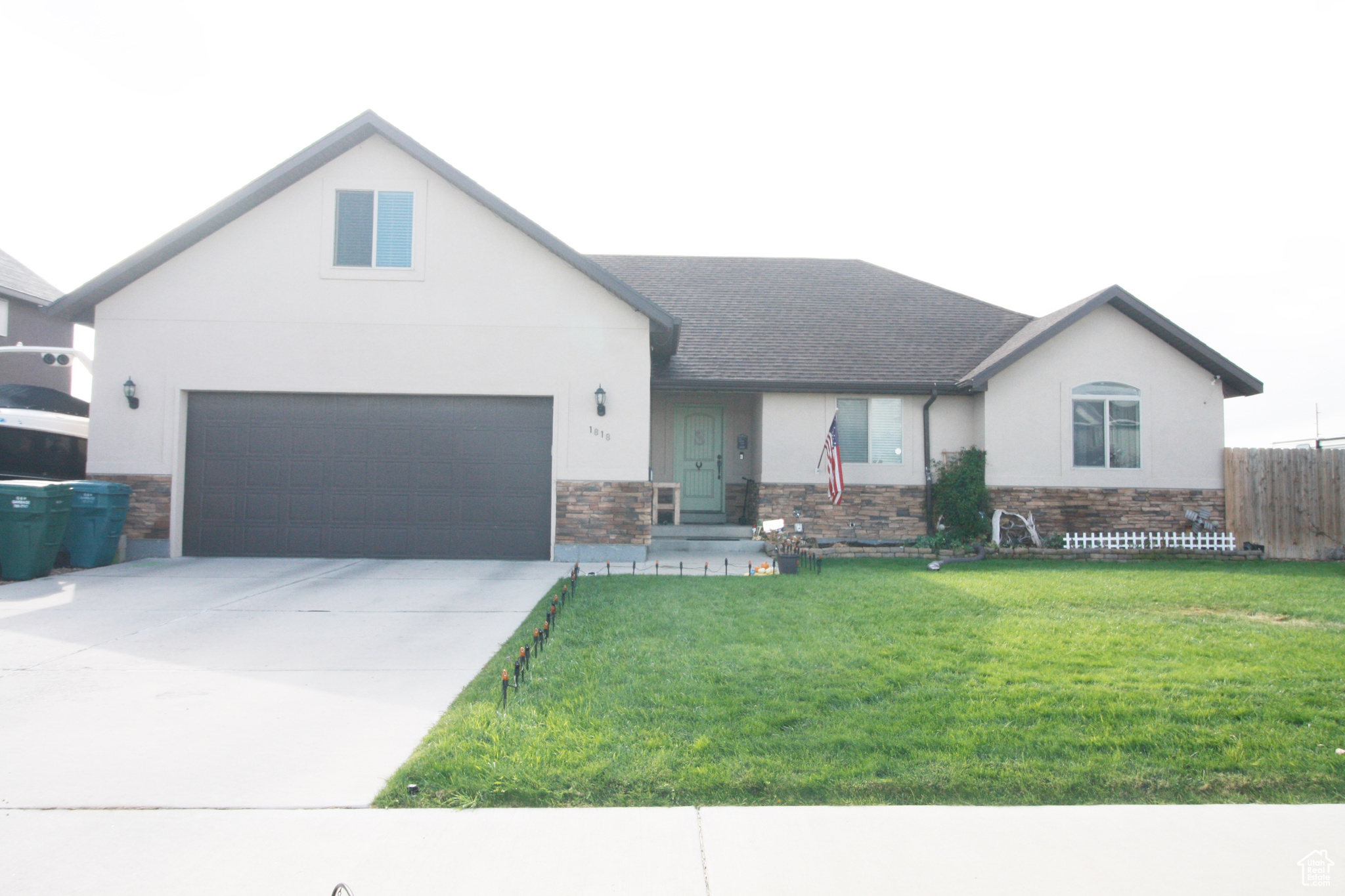 View of front of property with a front yard and a garage