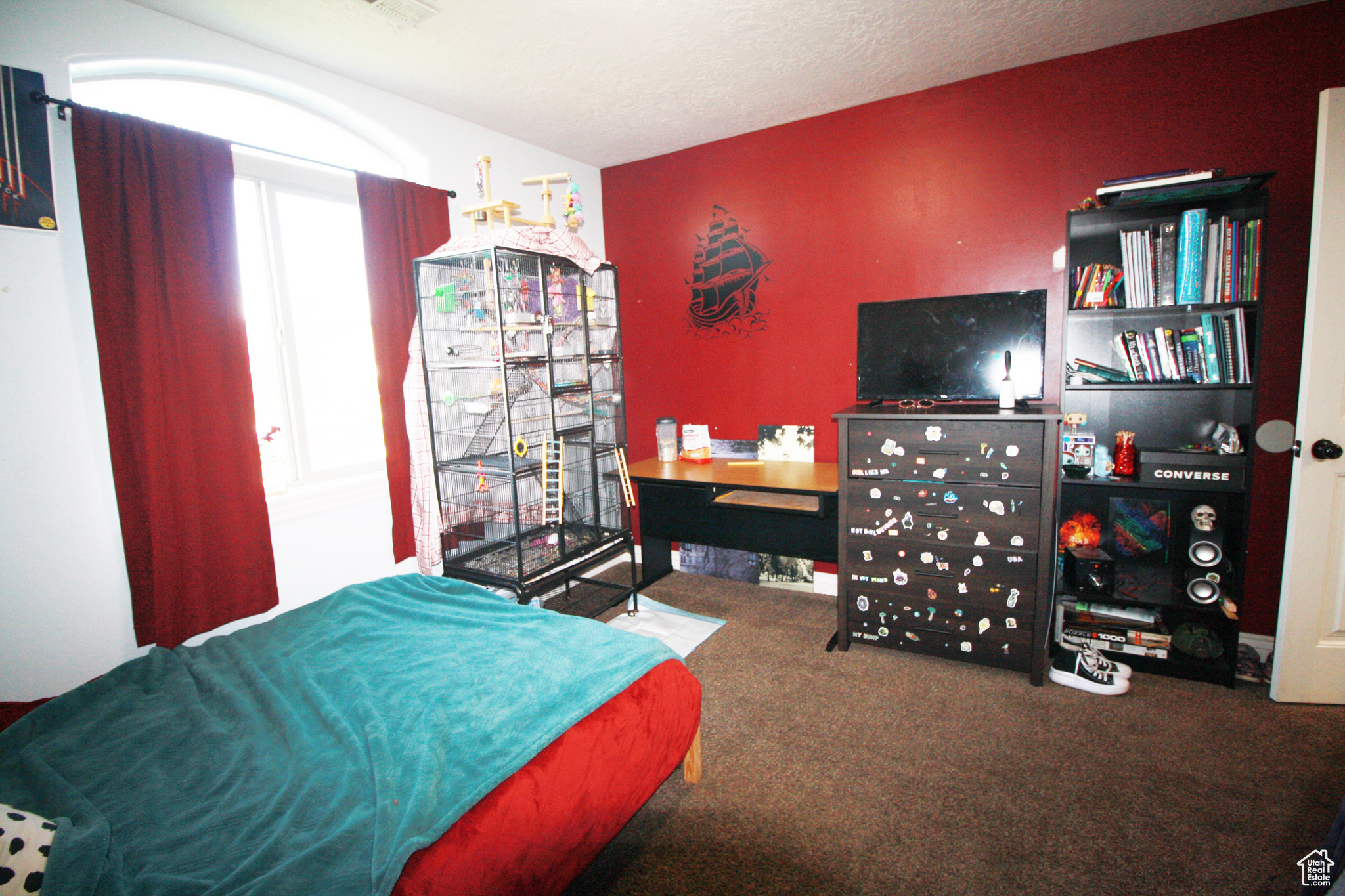 Bedroom with a textured ceiling and carpet floors, featuring a Ship.