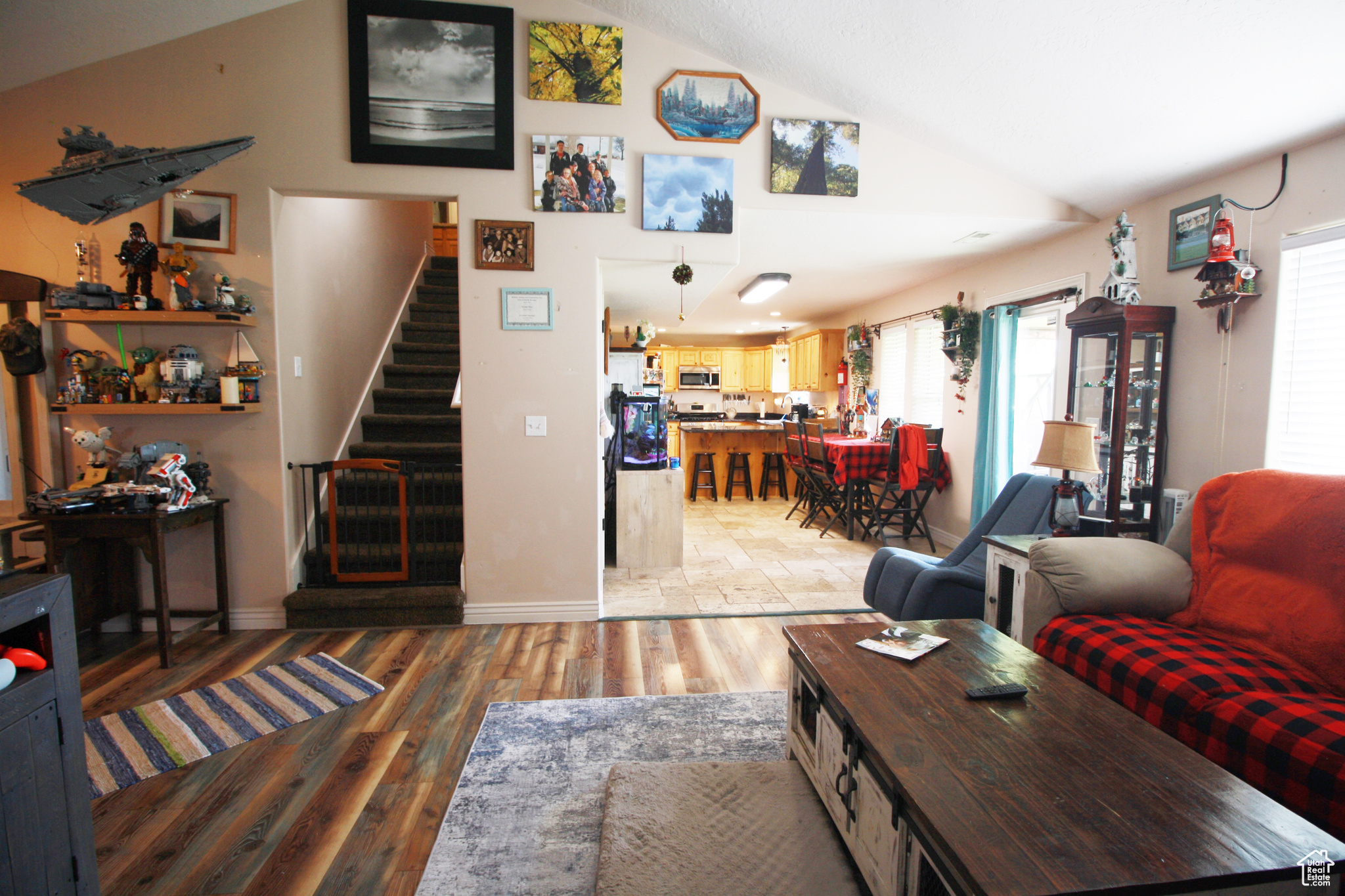 Living room with wood & travertine flooring and vaulted ceiling