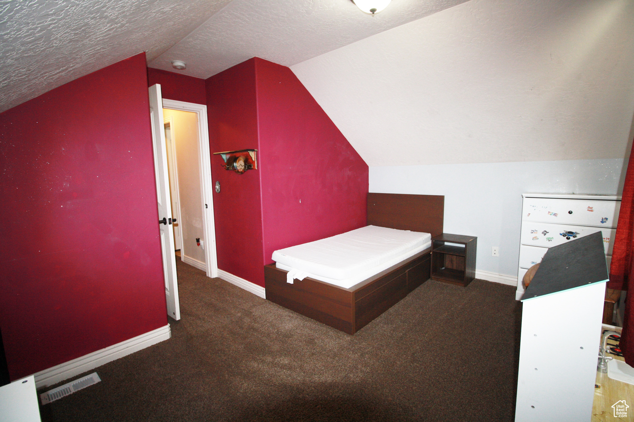 Carpeted bedroom 4, featuring vaulted ceiling and a textured ceiling