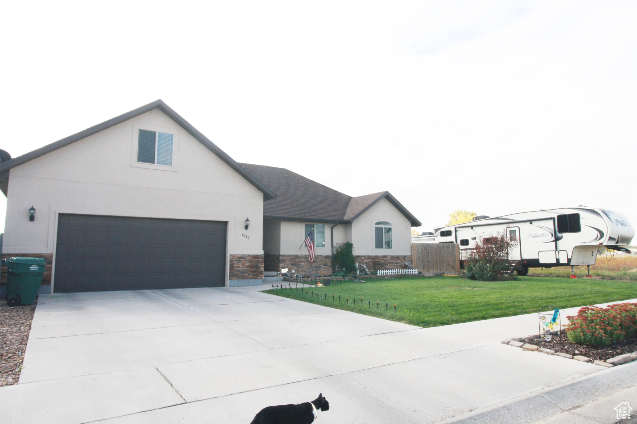 View of front facade featuring a front yard and a garage