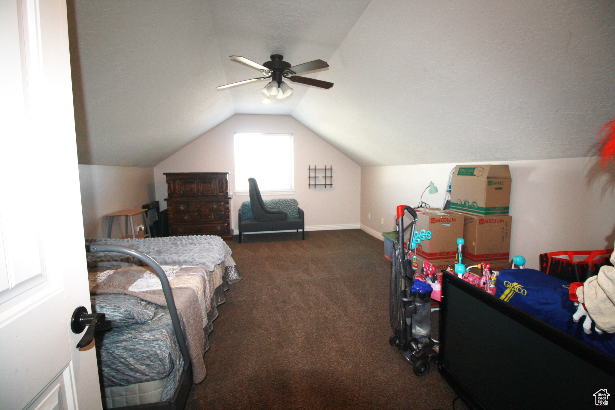 Carpeted bedroom 5, featuring vaulted ceiling and ceiling fan