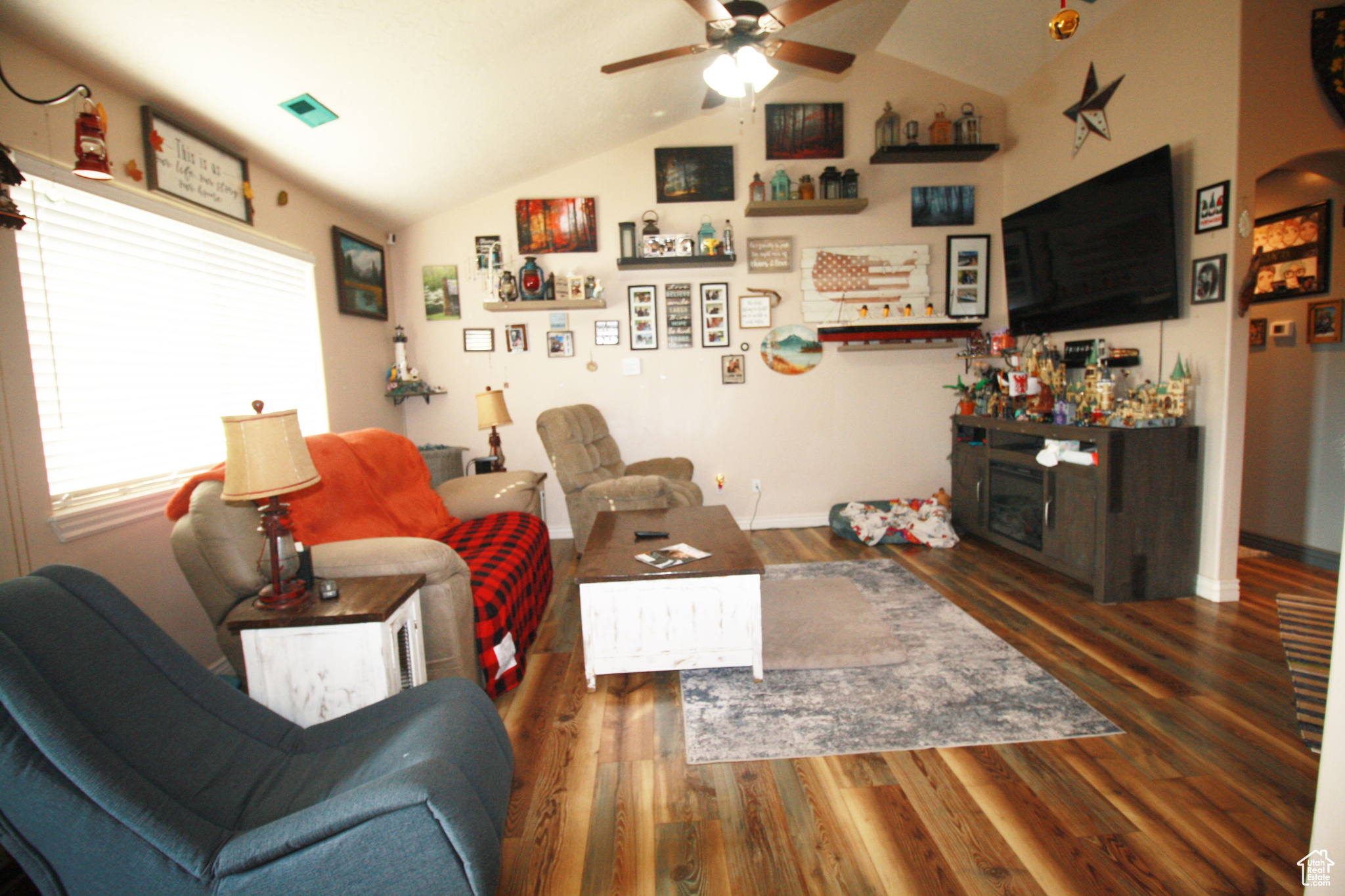 Living room with lofted ceiling, ceiling fan, and dark hardwood / wood-style flooring