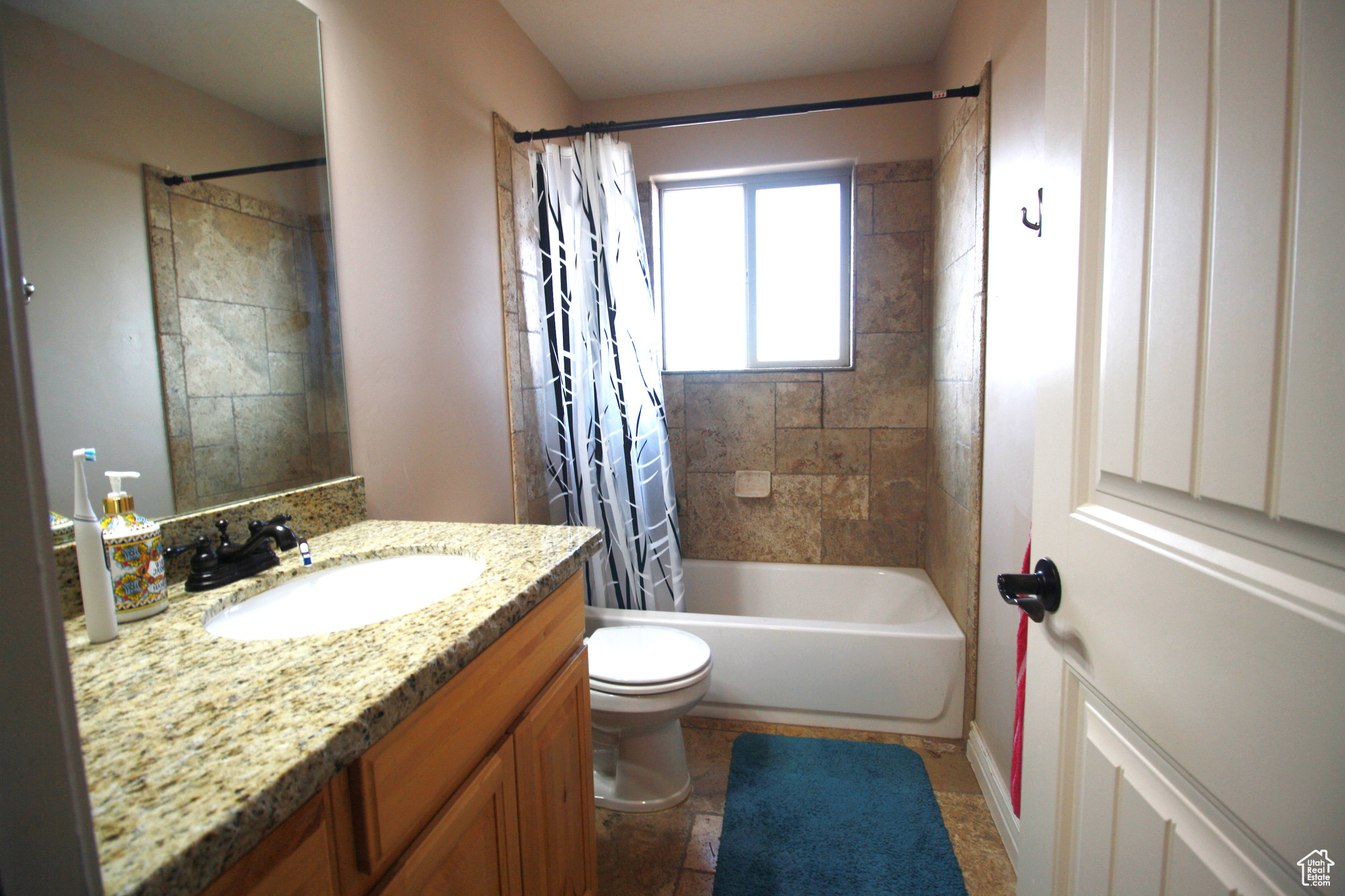 Full bathroom with toilet, shower / bath combination with curtain, and vanity