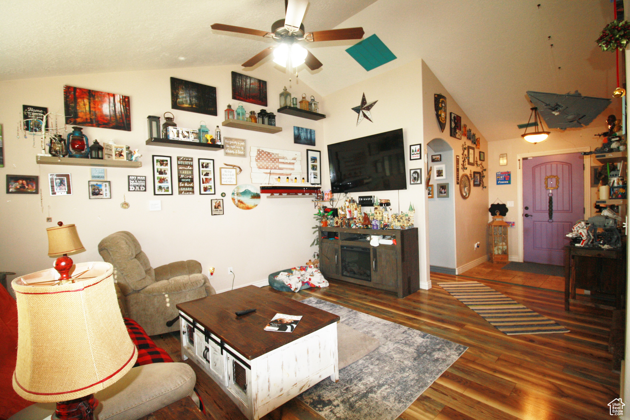 Living room featuring dark hardwood / wood-style floors, ceiling fan, and vaulted ceiling