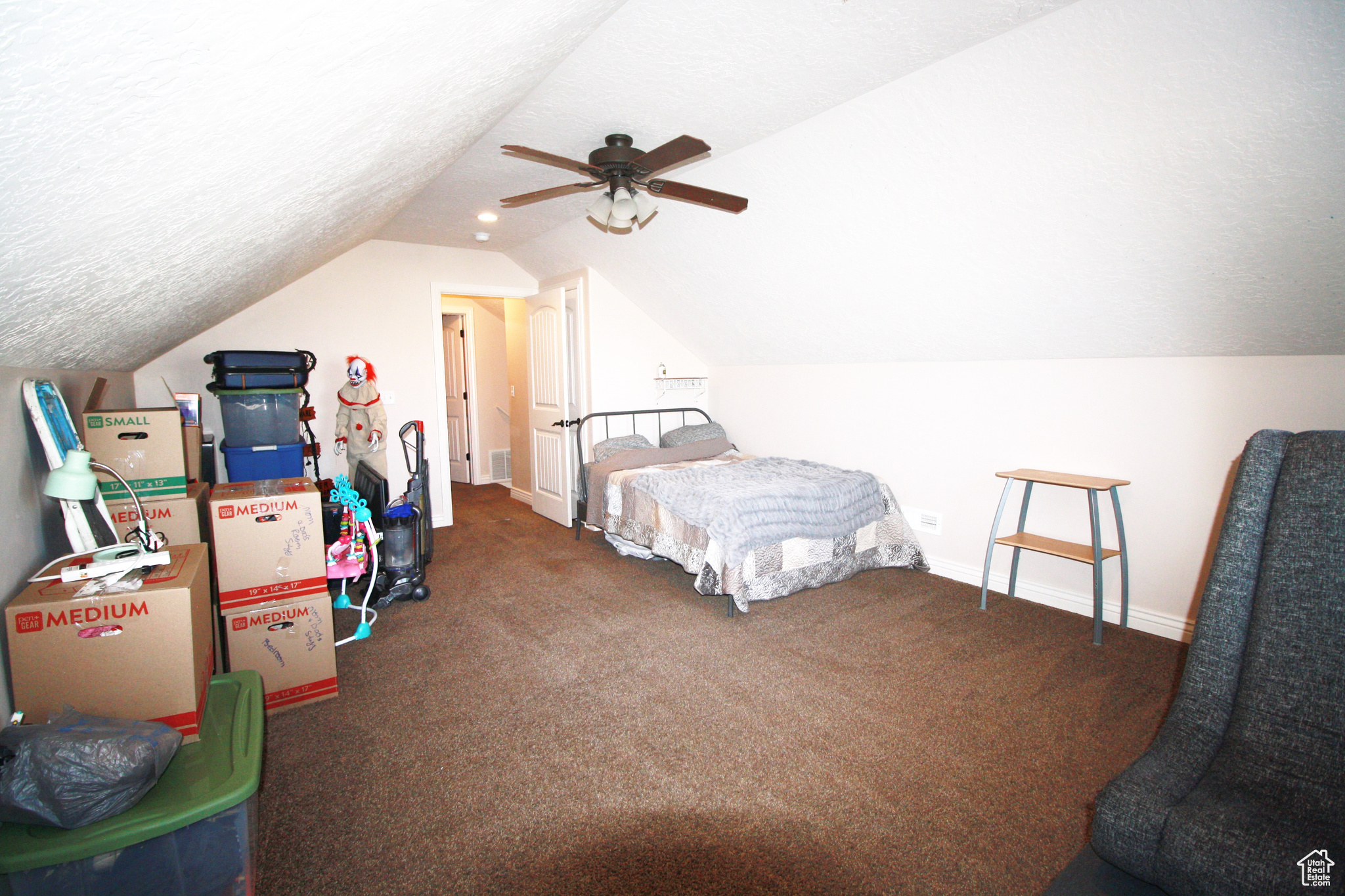 Bedroom 5, featuring dark carpet, lofted ceiling, and ceiling fan